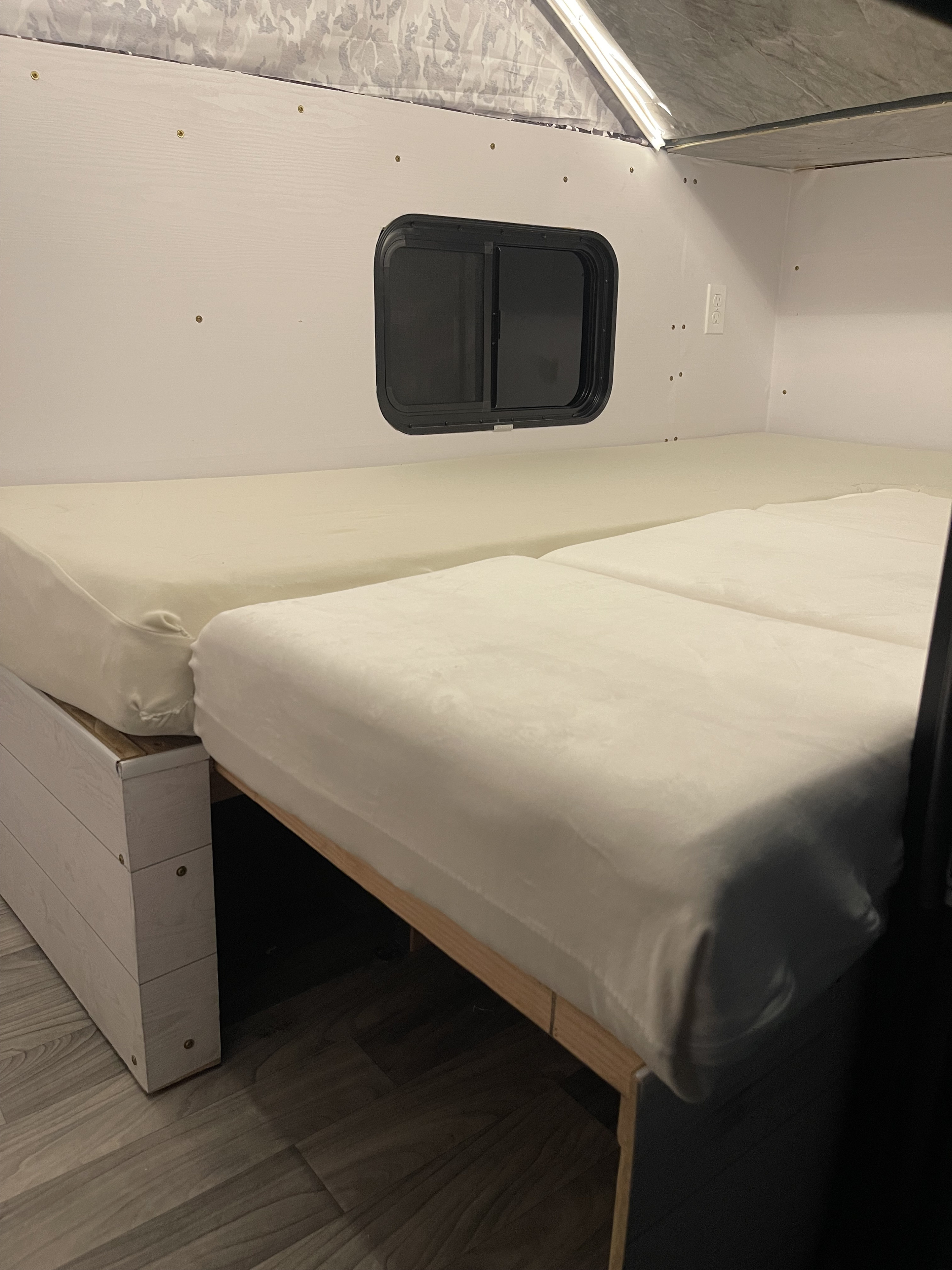 RV rental interior: Camper bed setup with two mattresses, a window, and a patterned pop-top ceiling.. Homemade Box 2020