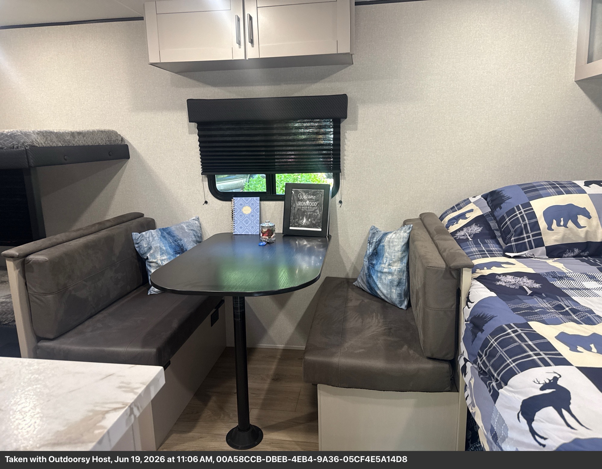 RV rental interior: dinette with benches, bunk bed, and a comfortable sleeping area with blue plaid bear bedding.. Jayco Jay Feather Air SL 2025