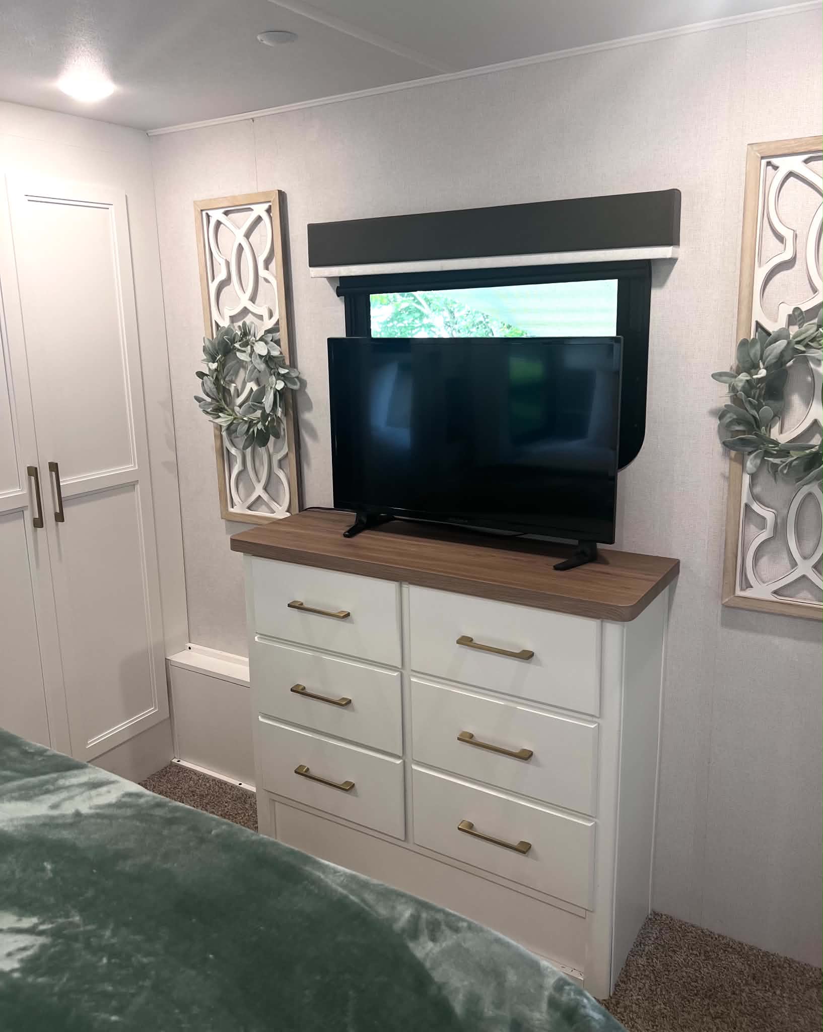 Inviting rv rental bedroom showing a white dresser with gold pulls, TV, window, and modern wall decor.. Crusader Crusader Fifth Wheel 2021