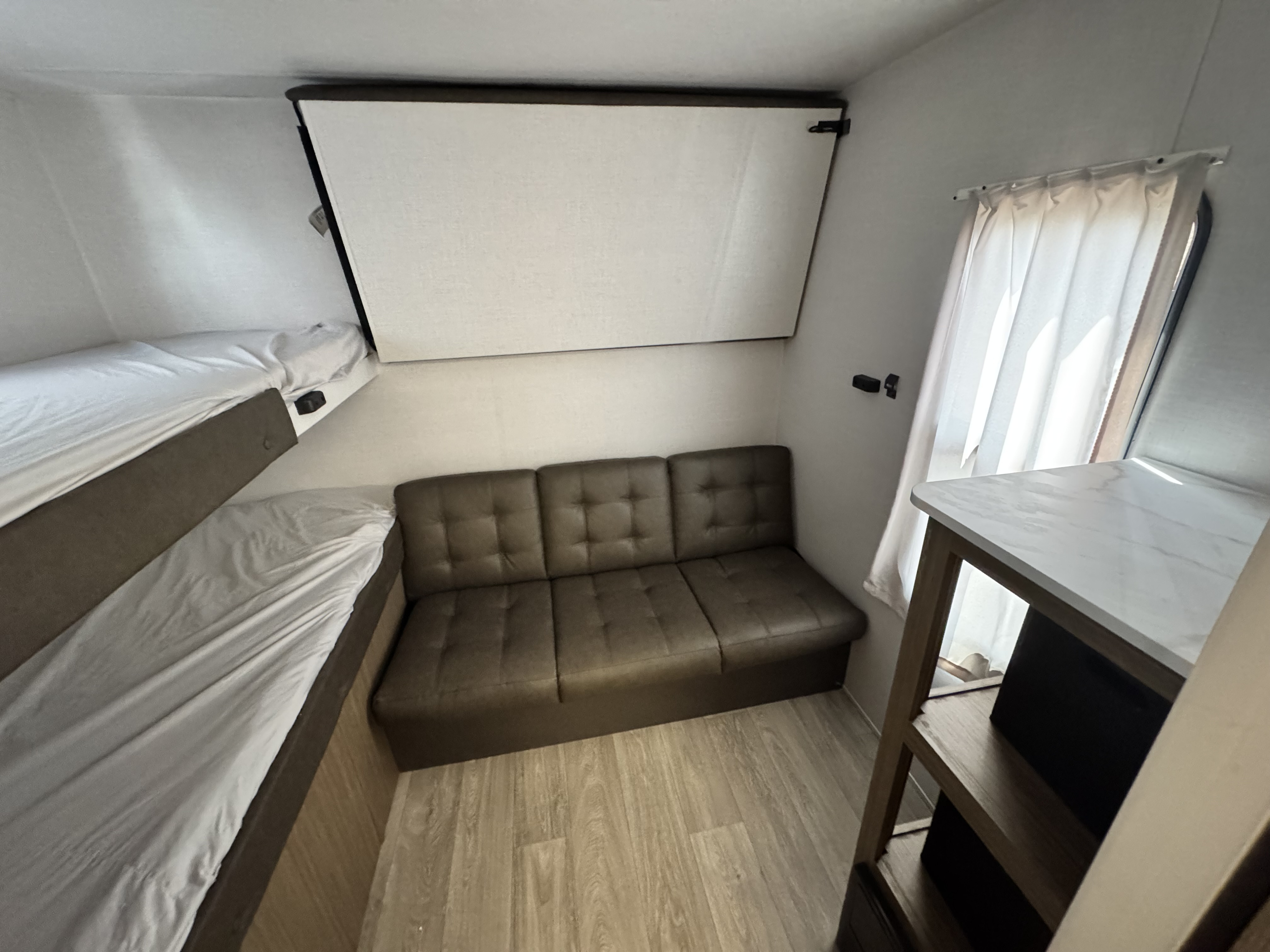 RV rental interior: A cozy space with bunk beds, a convertible sofa, and an upper fold-down bed for flexible sleeping.. Forest River Salem Cruise-Lite 2026