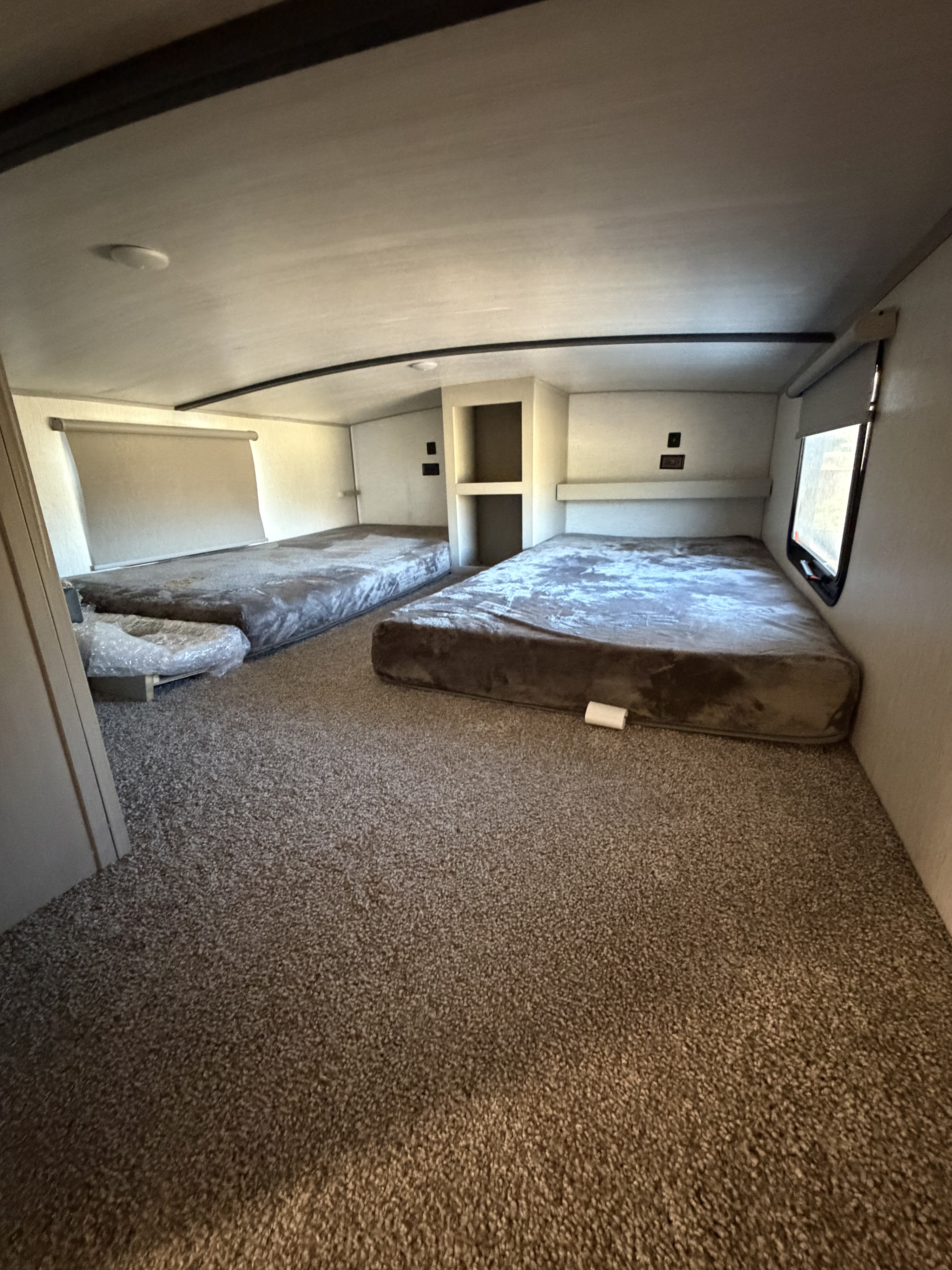 RV rental bunkhouse: two plush beds, soft carpet, window, and storage shelves. Ideal for family adventures.. Forest River Salem Hemisphere 2023