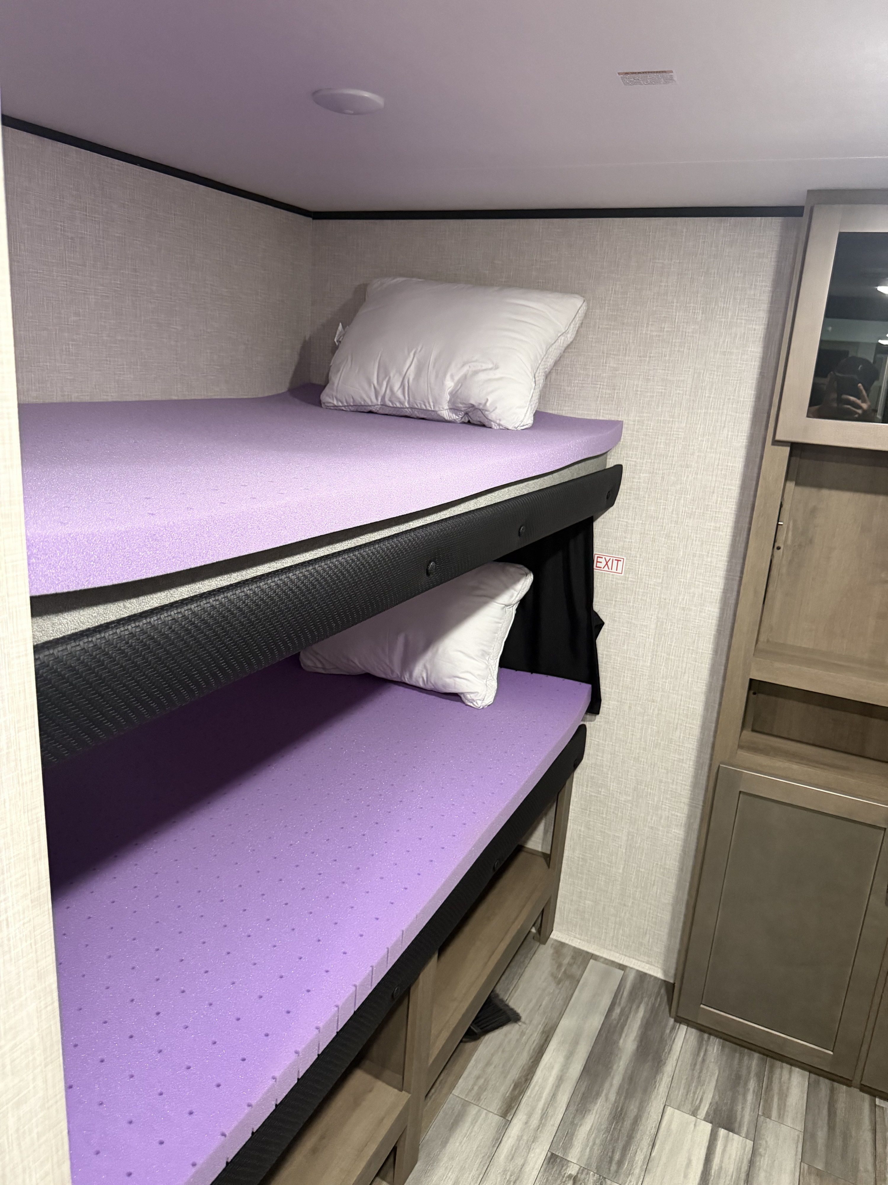 Cozy rv rental bunk beds with purple foam toppers and pillows, perfect for a compact sleeping area in an RV interior.. Jayco Jay Flight SLX STX Edition 2025