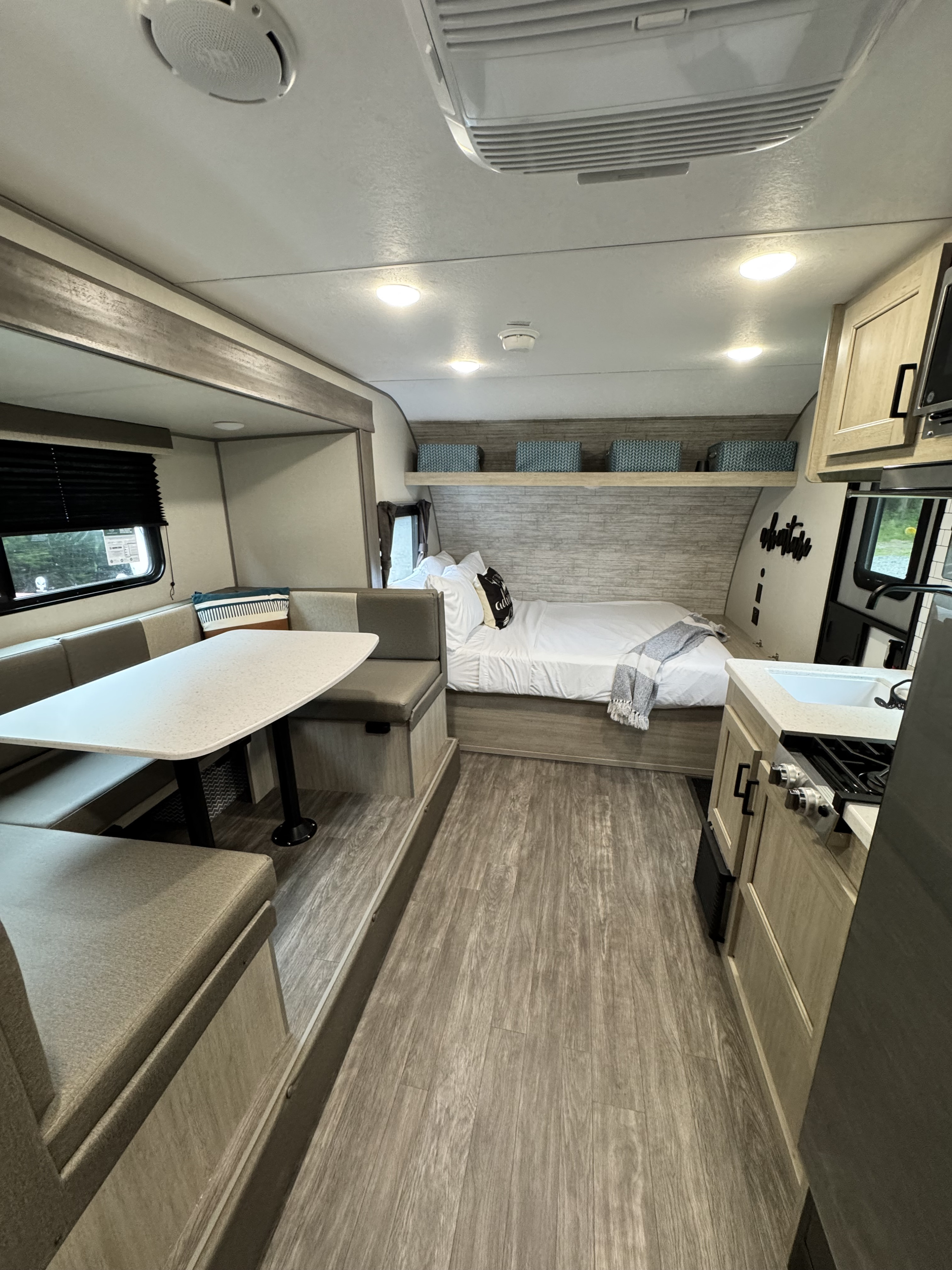 This modern rv rental camper interior features a comfy dinette, bed, and compact kitchen. Ready for your travels.. Forest River Aurora Aurora Light 2026