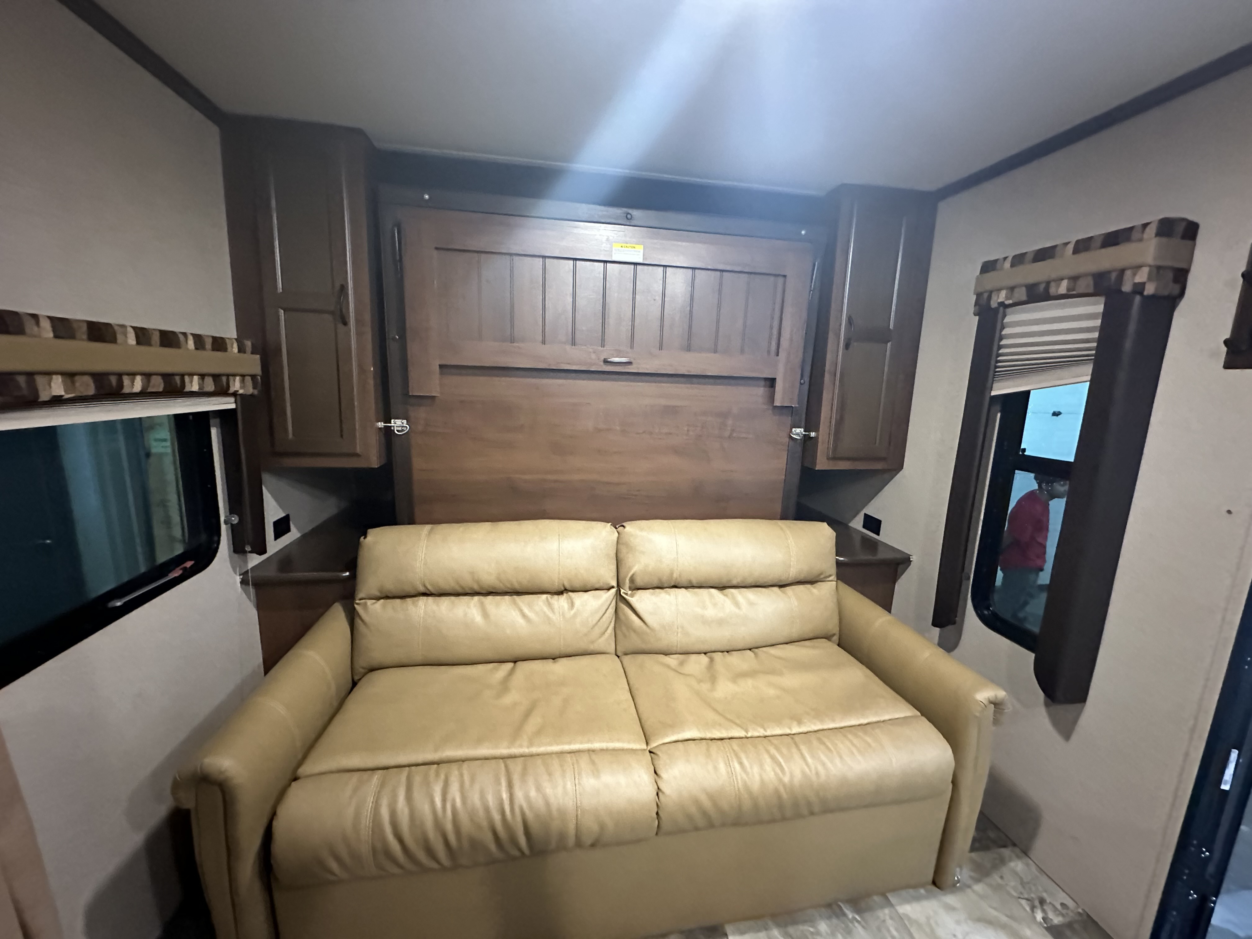 RV rental: Tan leather sofa, wooden wall bed, and cabinets create a cozy interior, perfect for comfortable travel experiences.. Jayco Jay Flight 2015