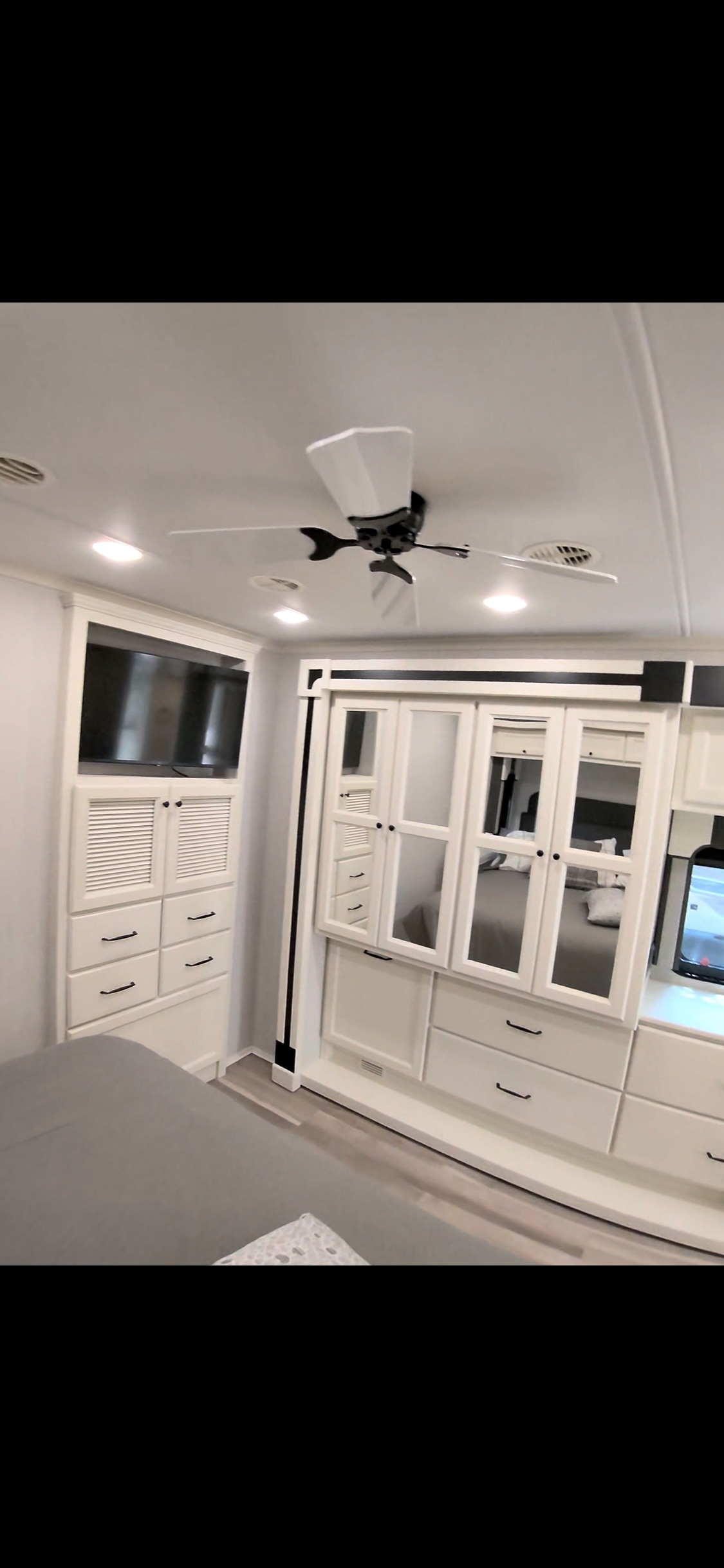 Bright RV rental bedroom with white cabinetry, TV, ceiling fan, and bed for comfortable travel.. Allegro Allegro Open Road 2026