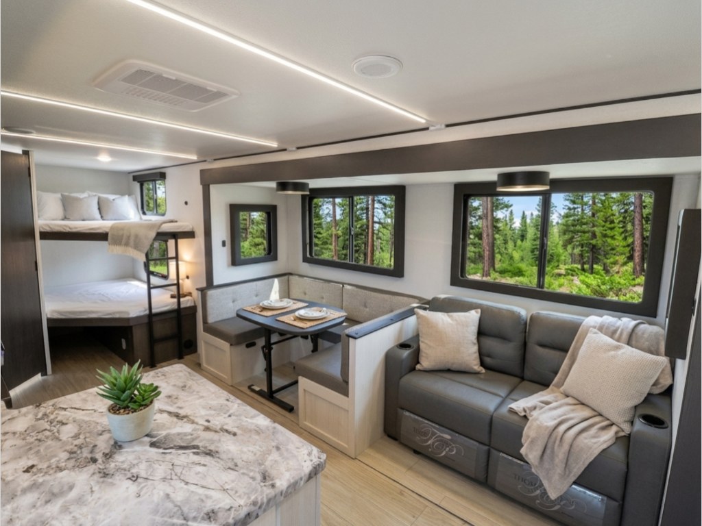 Spacious RV rental interior with bunk beds, a dinette, and a comfortable sofa, ideal for family travel.. Forest River Valley Ridge 2026
