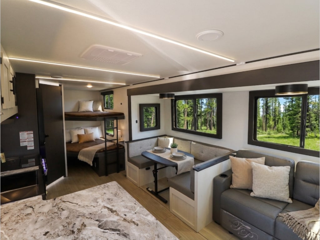 Modern rv rental interior with bunk beds, dining nook, and living area with sofa, offering scenic views for your trip.. Forest River Valley Ridge 2026