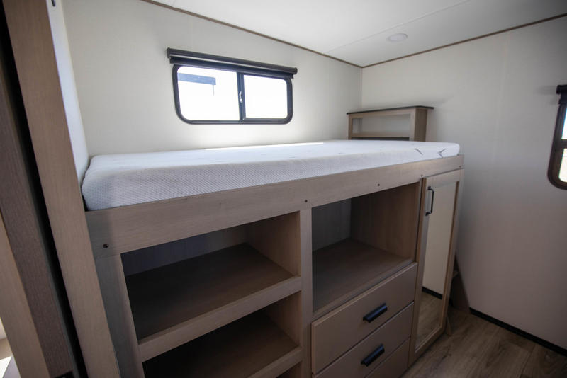 RV rental interior featuring a bunk bed with integrated storage, including shelves, drawers, and a mirrored cabinet.. Grand Design Reflection 100 2026