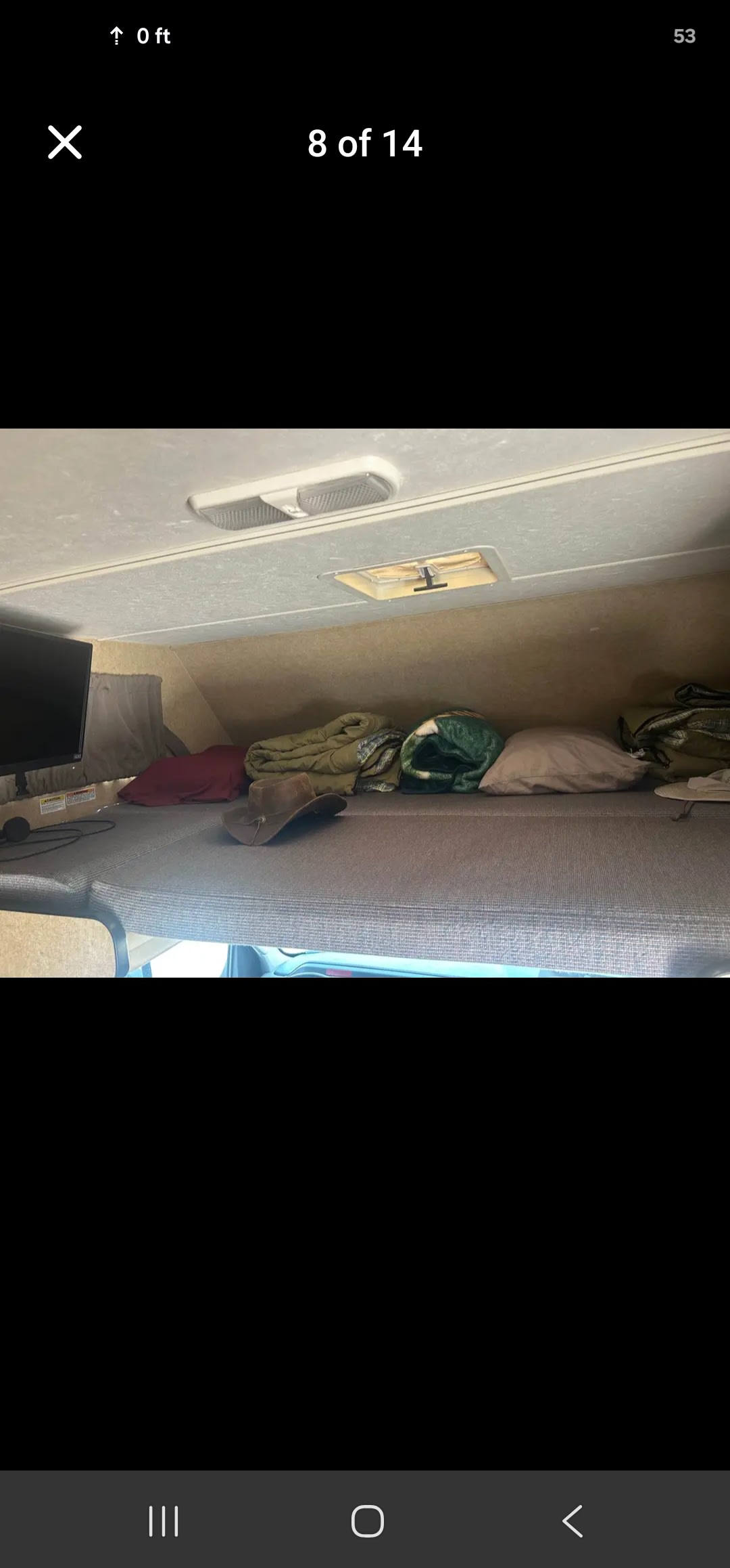 Cozy RV rental overhead bunk with a TV, blankets, pillows, and a hat, ready for your adventure.. Thor Majestic 2017