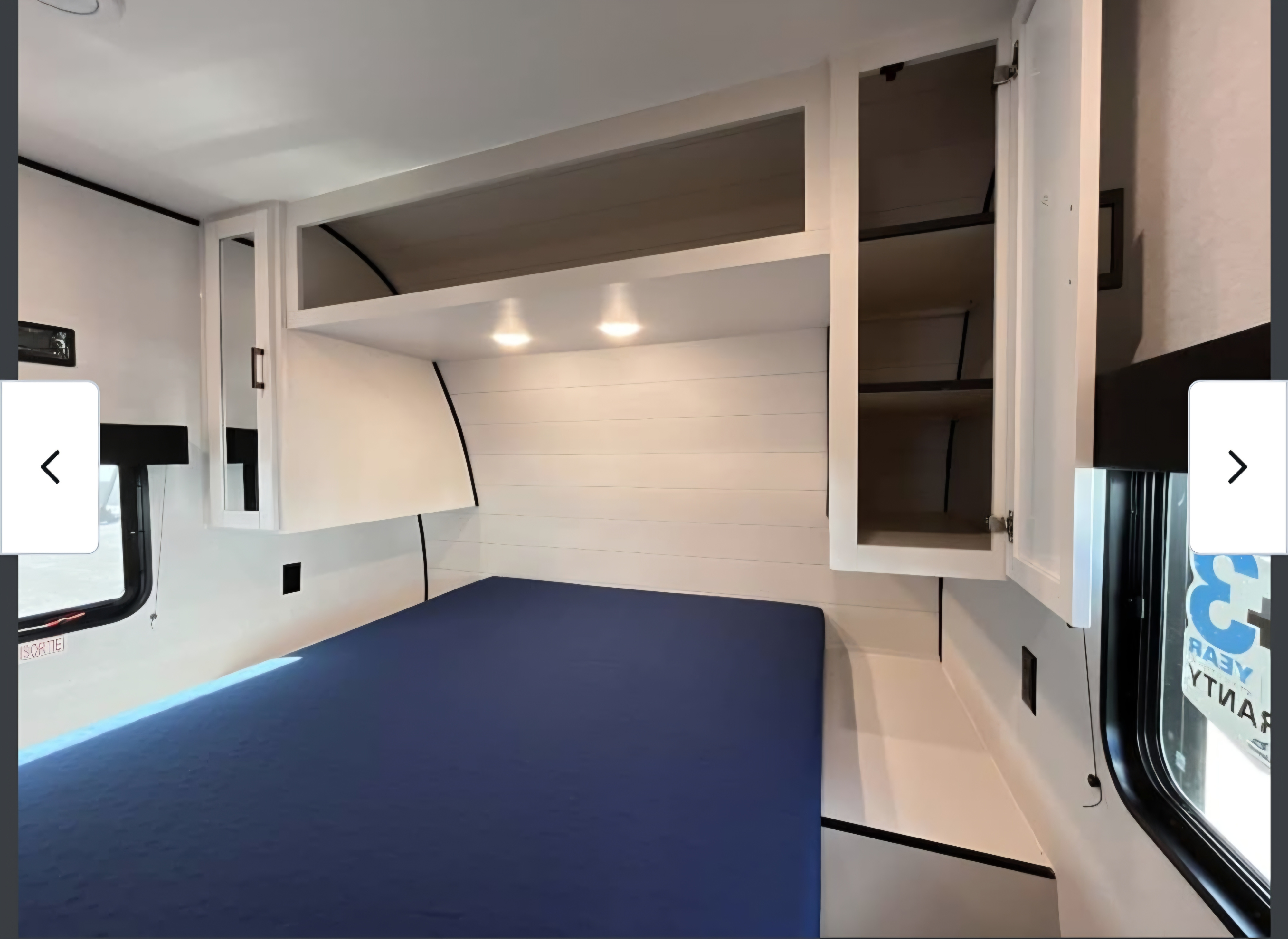 Spacious RV rental bedroom featuring a blue mattress, ample overhead storage, and clean white shiplap walls.. Jayco Jay Flight Six 2026