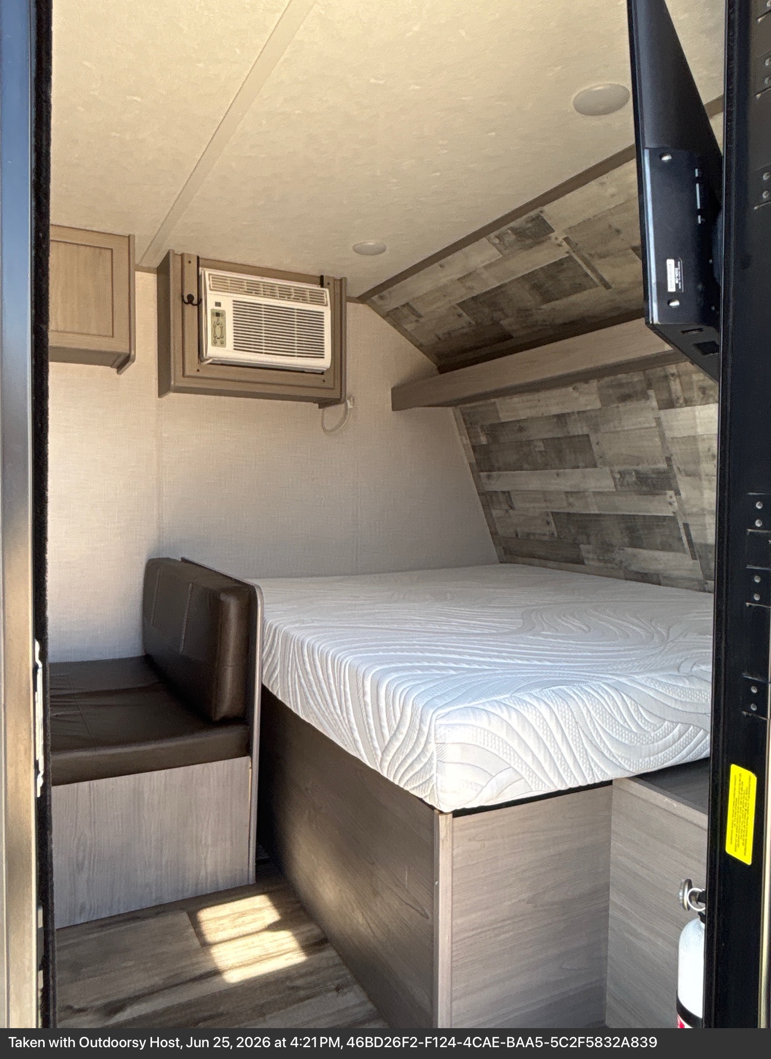 Cozy RV rental bedroom featuring a comfortable bed, dinette seating, wall-mounted AC, and TV for your next adventure.. Dutchmen Coleman Lantern LT 2022