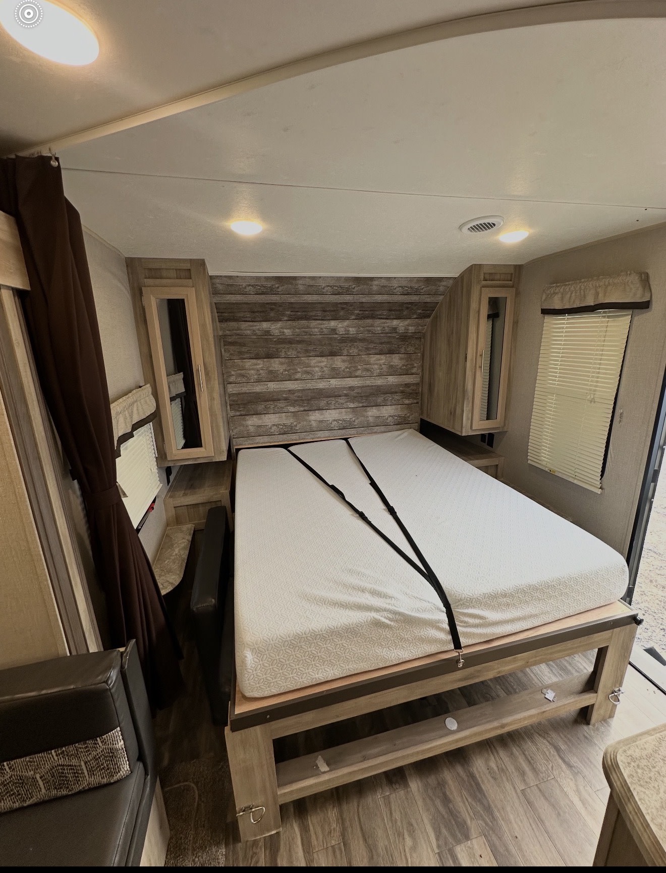 RV rental bedroom: a cozy interior featuring a patterned bed with security straps, overhead storage, and window blinds.. Coachmen 5ZT2CALB9LU036851 2020