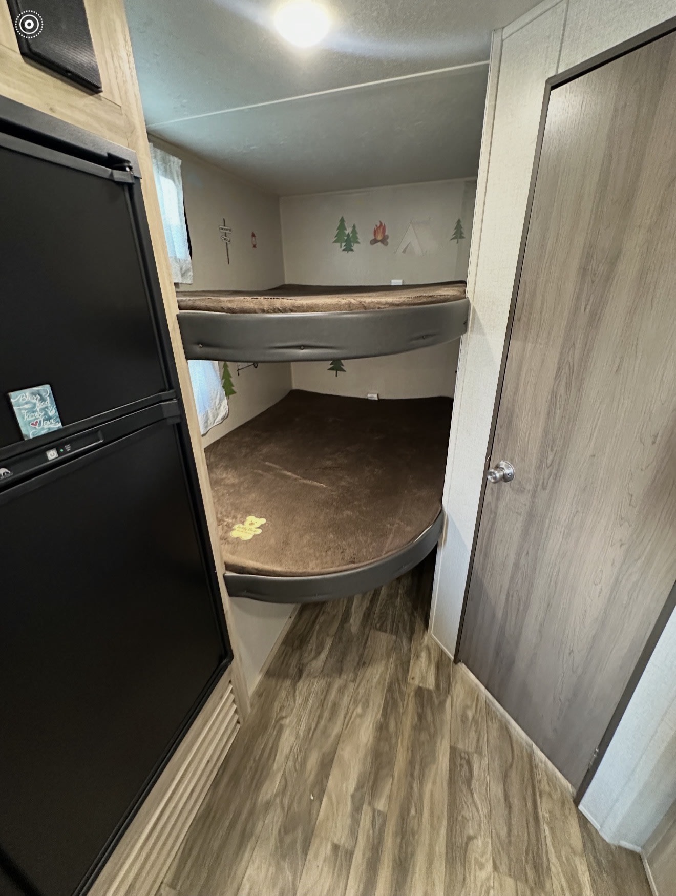 RV rental bunk beds with brown mats and playful camping decals. A black refrigerator is on the left, perfect for family adventures.. Coachmen 5ZT2CALB9LU036851 2020
