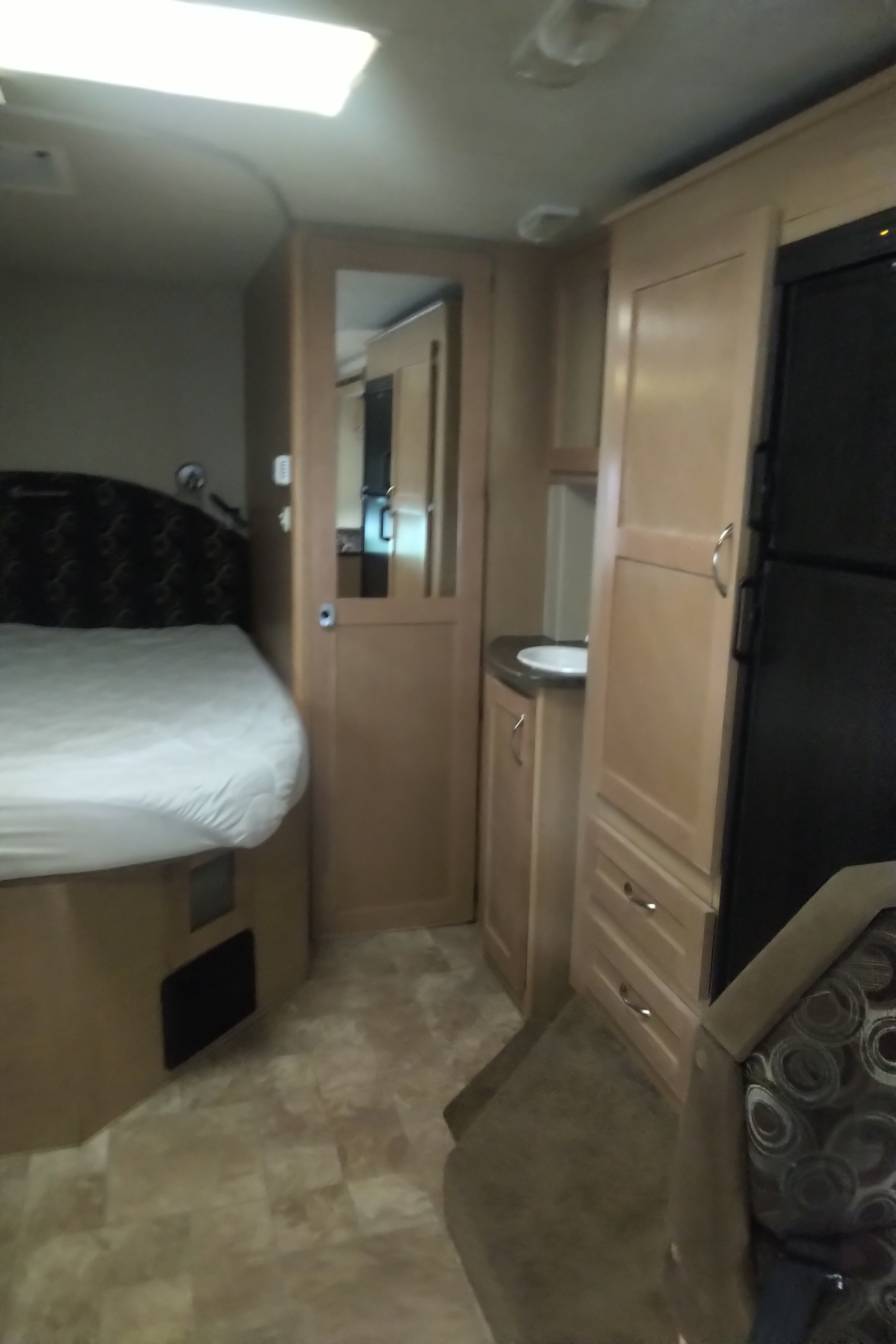 Explore this RV rental's interior: bedroom, mirrored door, vanity, fridge, and ample storage cabinets.. Adventurer Adventurer Motorhome 2012