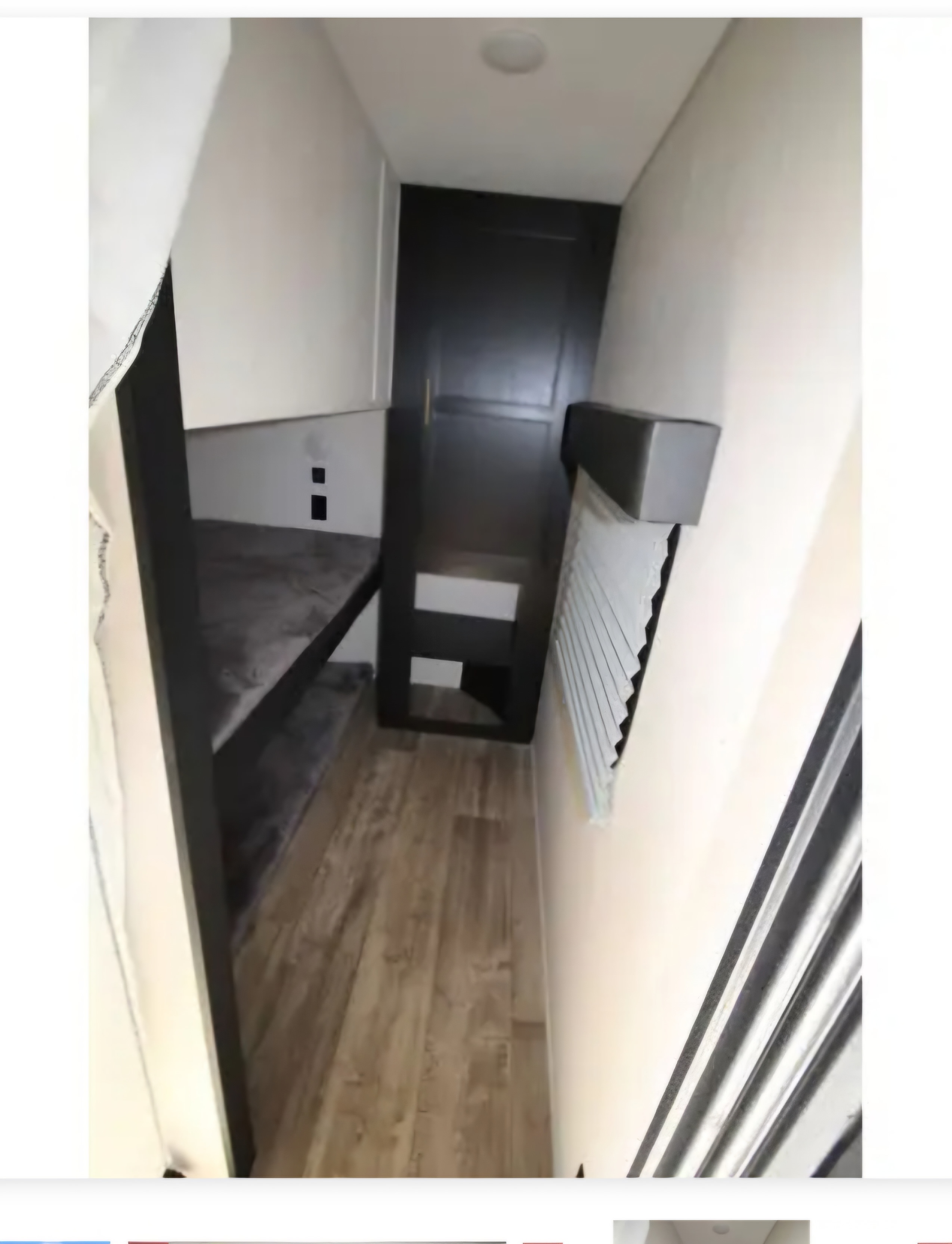 Cozy bunk bed sleeping area inside an RV rental. Features a dark bunk, wood-look floor, window blinds, and compact design.. Forest River Cherokee 2022