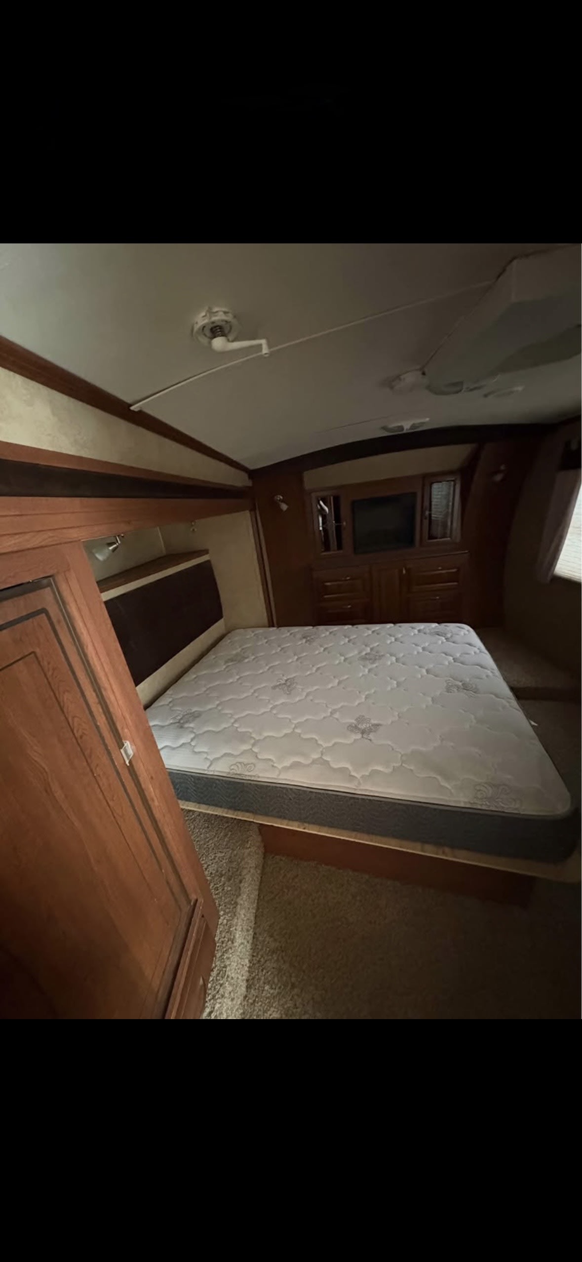 RV rental: Cozy bedroom featuring a queen mattress, wooden cabinetry, and a television for a comfortable stay.. Forest River Wildcat Sterling 2012