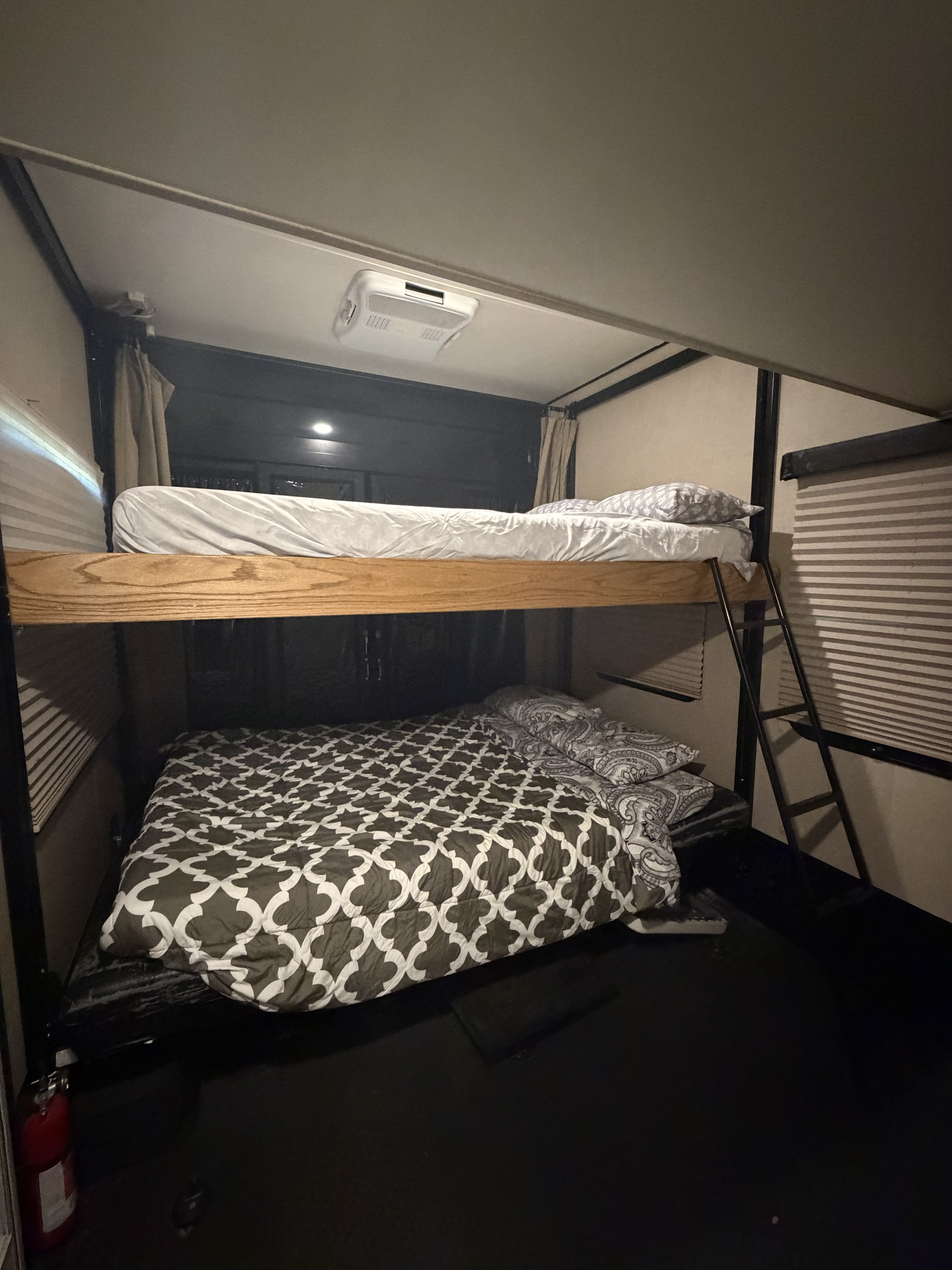 Cozy rv rental bunk beds with clean linens and a safety extinguisher, ready for comfortable family sleeping in an RV.. Denali Denali Fifth Wheel 2017