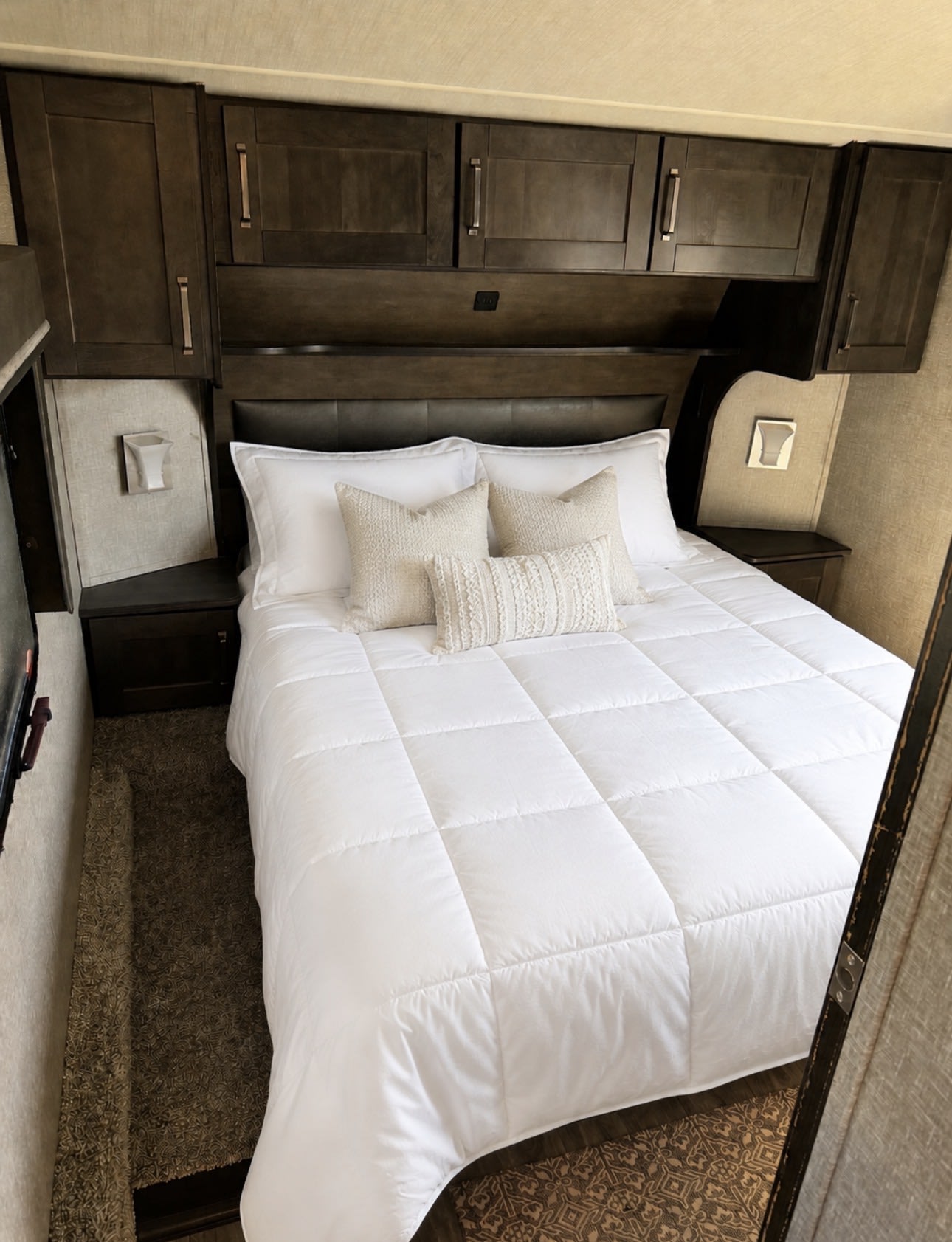RV rental bedroom: a cozy retreat with a queen bed, crisp white comforter, and dark wood storage. Ready for your travels.. Grand Design Reflection 150 2023