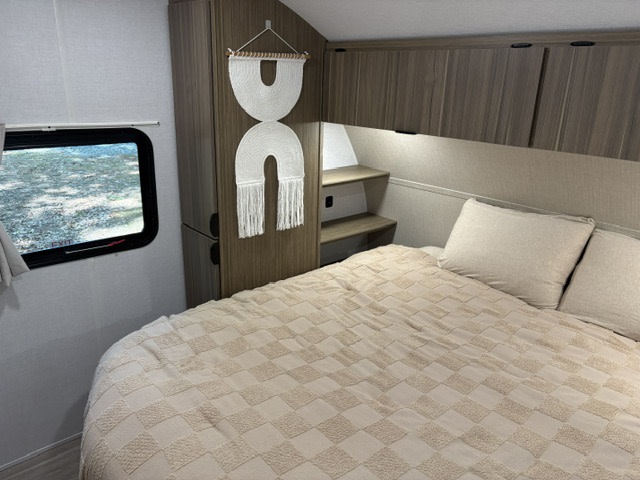 Cozy RV rental bedroom features a comfy bed, window view, built-in storage, and decor, perfect for travel.. Forest River Salem Cruise-Lite 2026