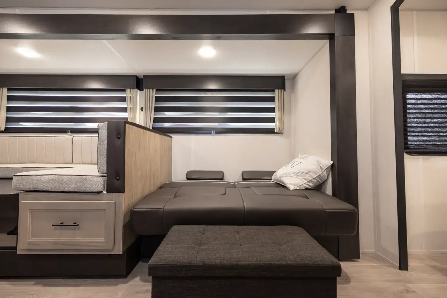 Spacious RV rental interior featuring a light-toned dinette, dark convertible bed, and ottoman for comfortable travel.. Forest River Cherokee Grey Wolf 26KF 2026
