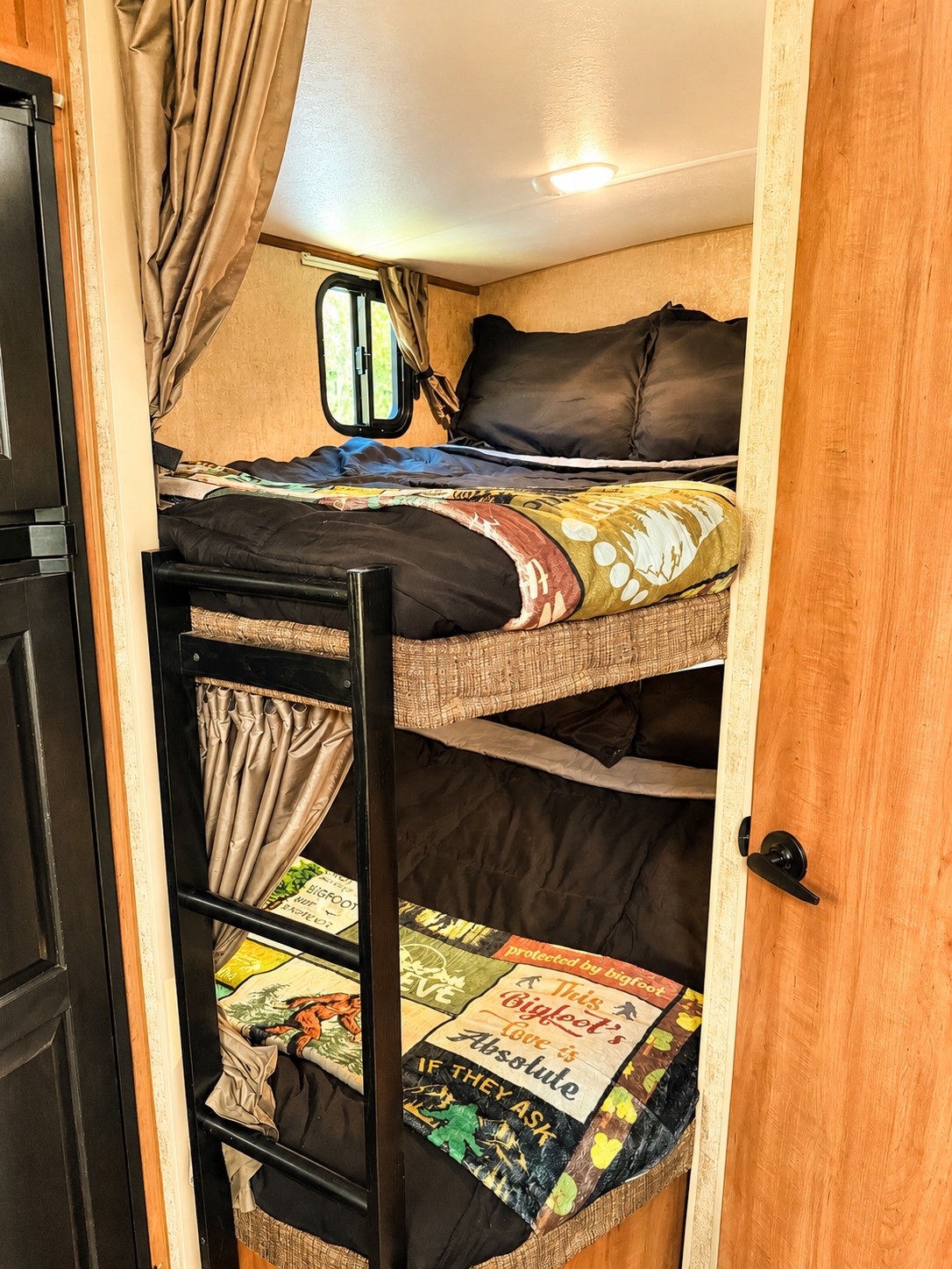 Cozy bunk beds in an RV rental, complete with Bigfoot-themed blankets for a fun adventure.. Outdoors RV Mountain Trax Backcountry 2024