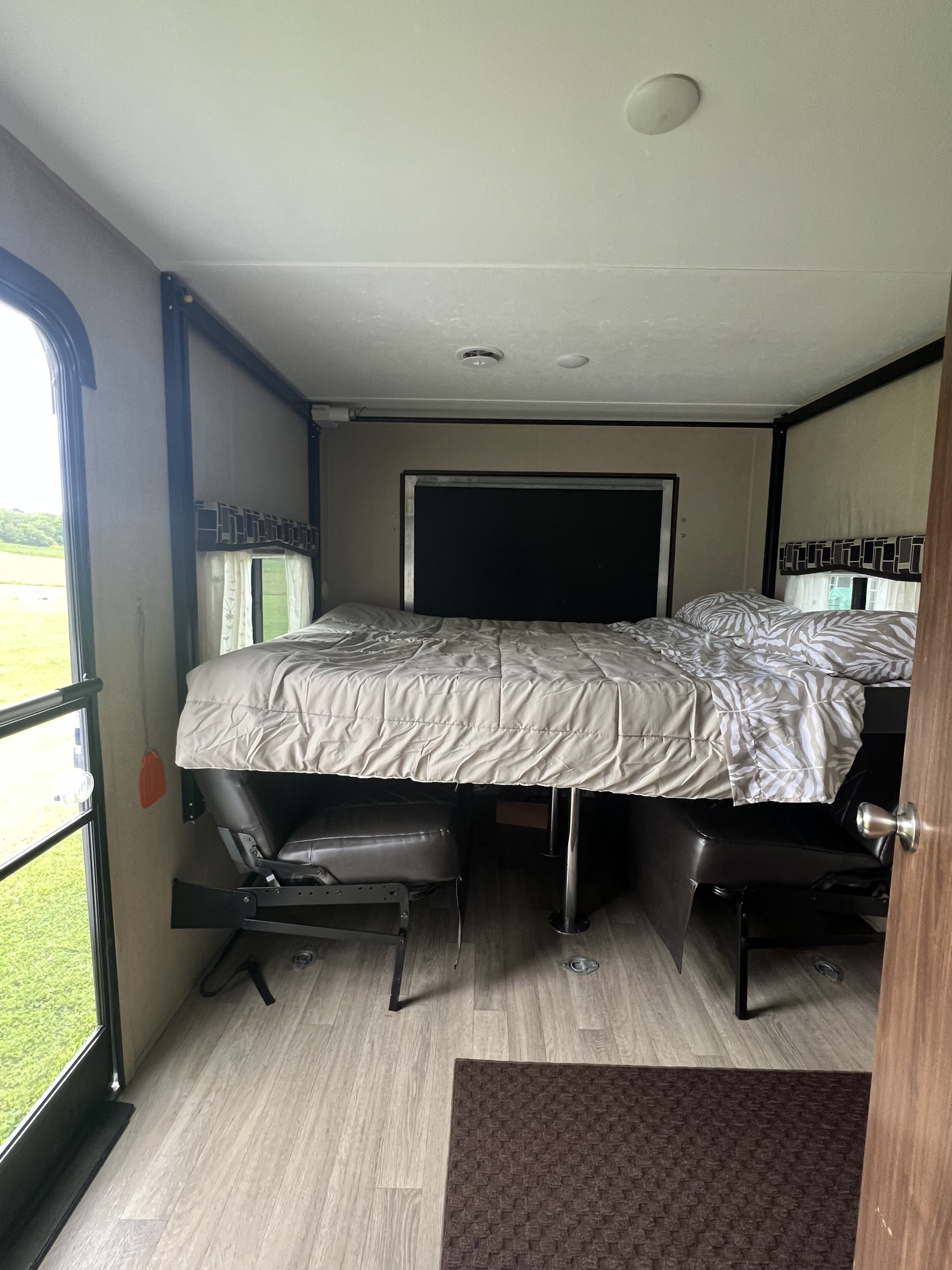Cozy RV rental interior showing a drop-down bunk bed above convertible seating, ideal for flexible travel space in your camper.. Coleman Lantern Series 2016