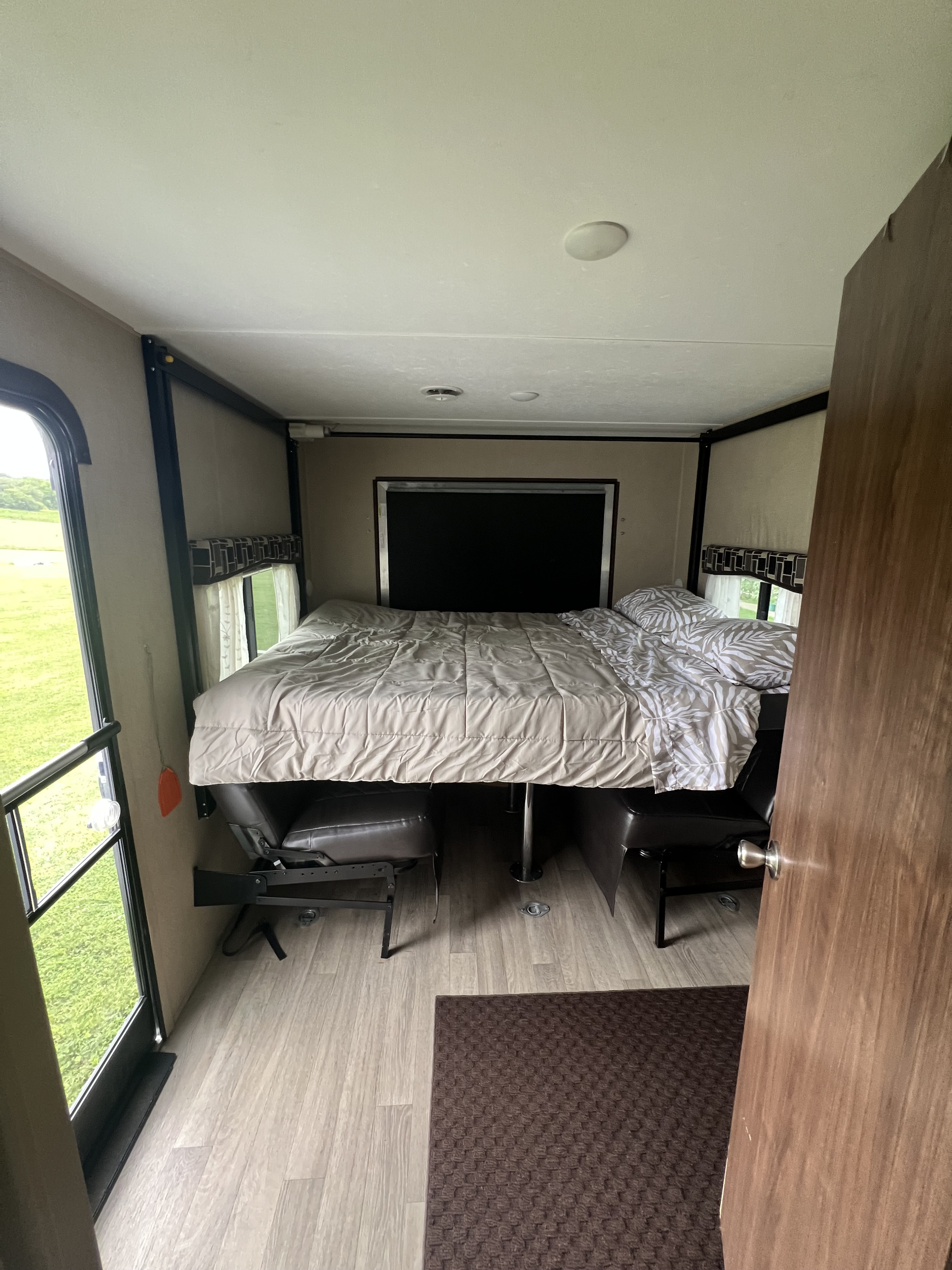 RV rental interior featuring a lowered bed over convertible seating/dining, with outdoor views and wood flooring.. Coleman Lantern Series 2016