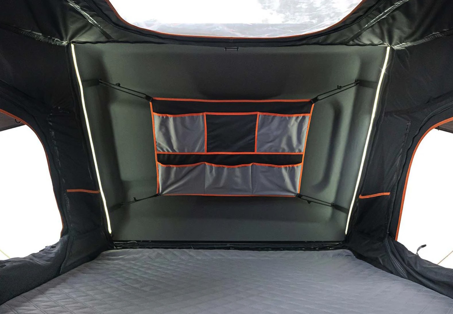 Cozy RV rental interior: a comfortable sleeping area with quilted mattress, integrated storage pockets, and mood lighting for camping.. Toyota Tacoma 2026