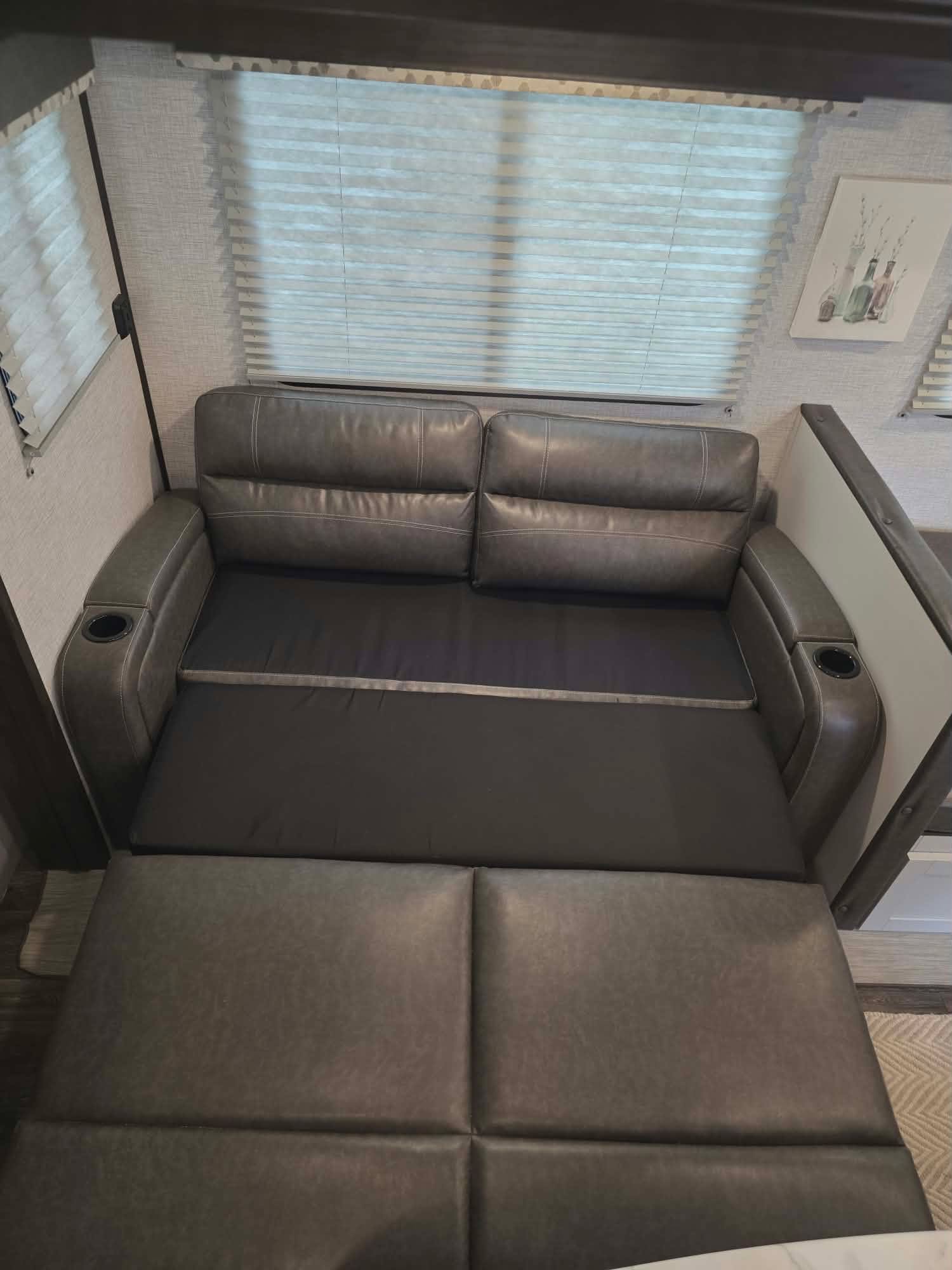 Comfortable pull-out sofa in an RV rental, converting to a sleeping area for added space and convenience.. Keystone RV Bullet Ultra Lite 2021