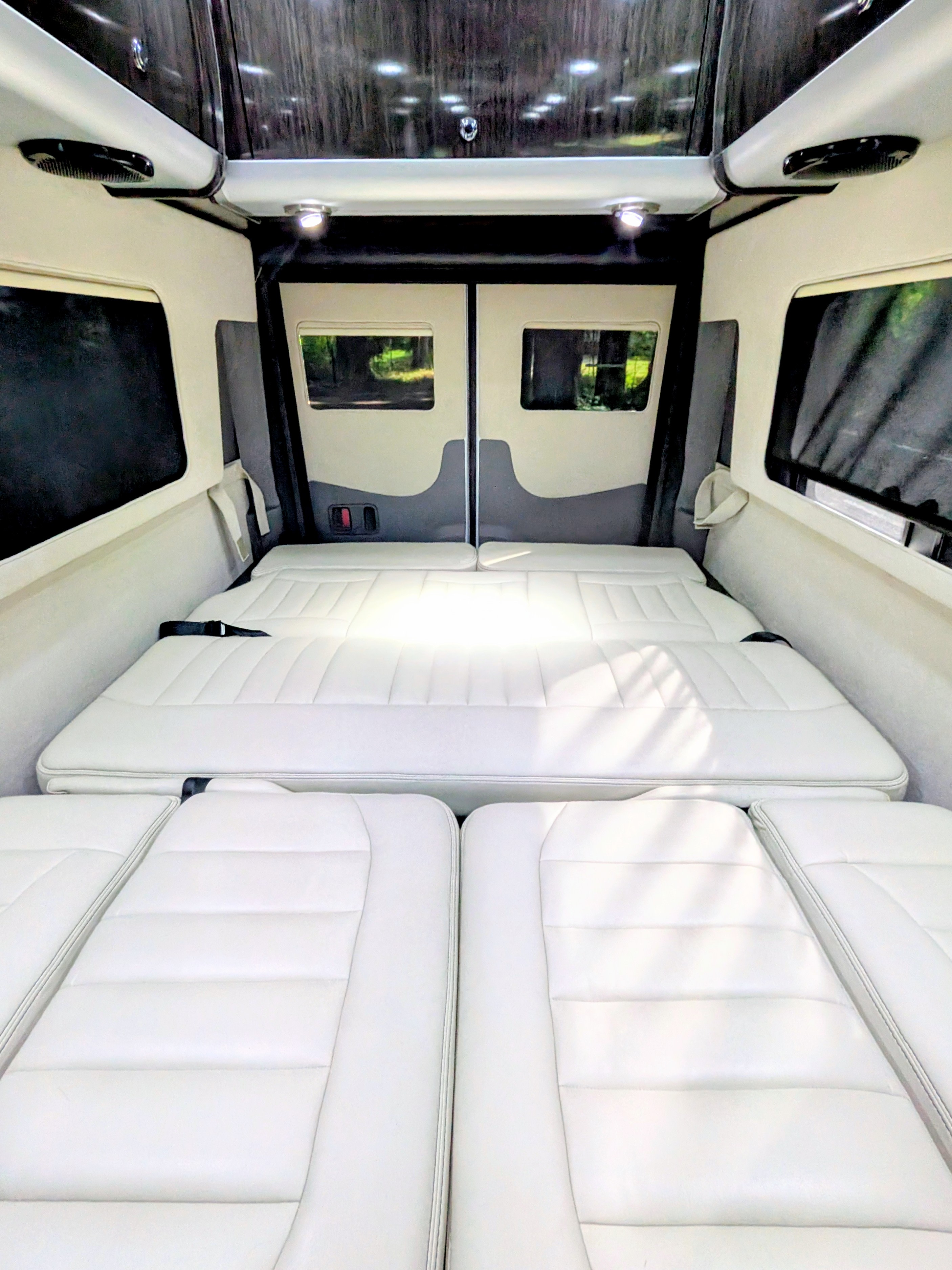 RV rental camper van interior with a comfortable white bed setup for travelers.. Airstream Interstate 2017