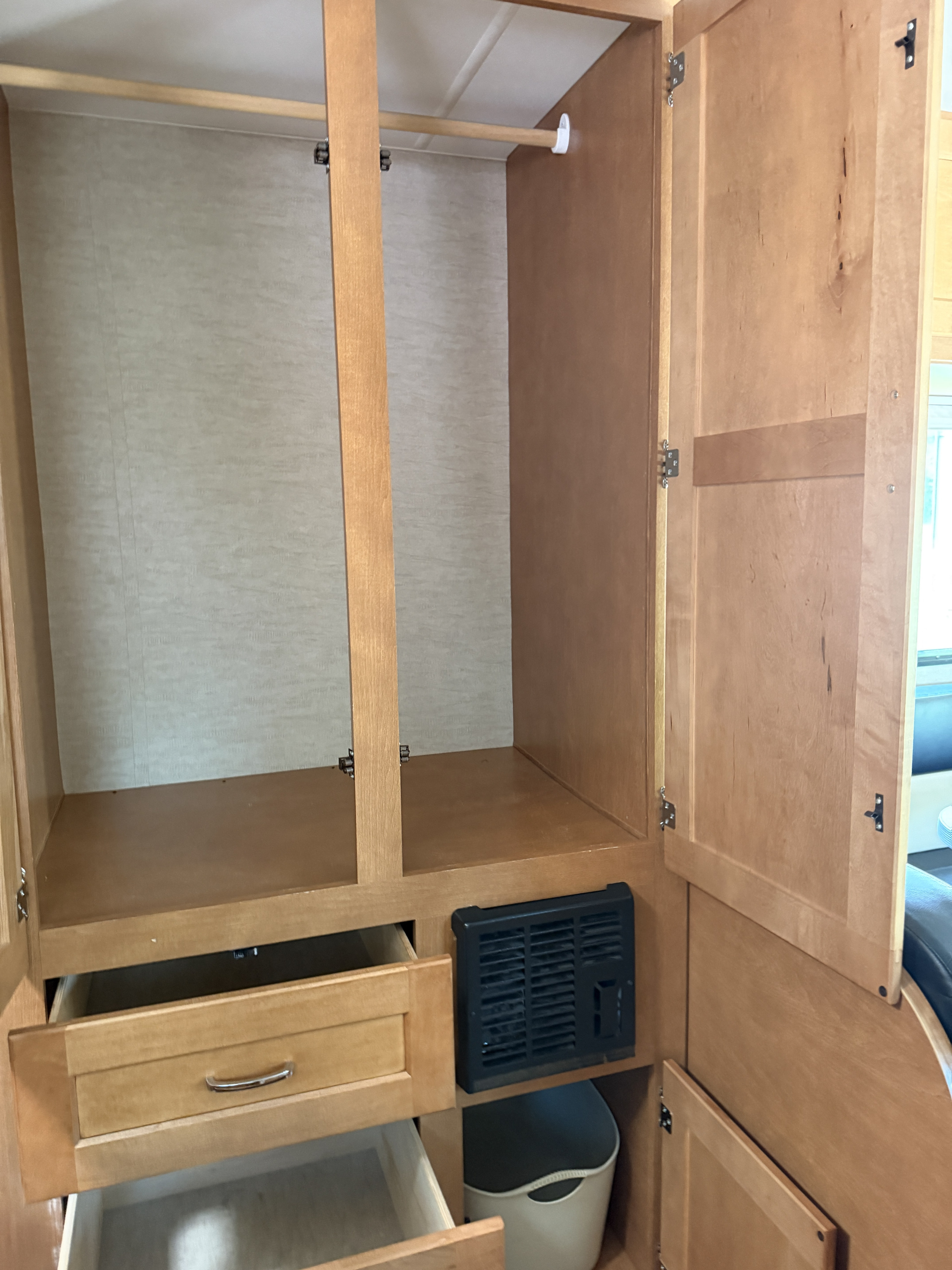 RV rental interior: wood closet with open doors, hanging rod, shelf, and drawers, showing compact storage solutions.. Itasca Spirit 2016