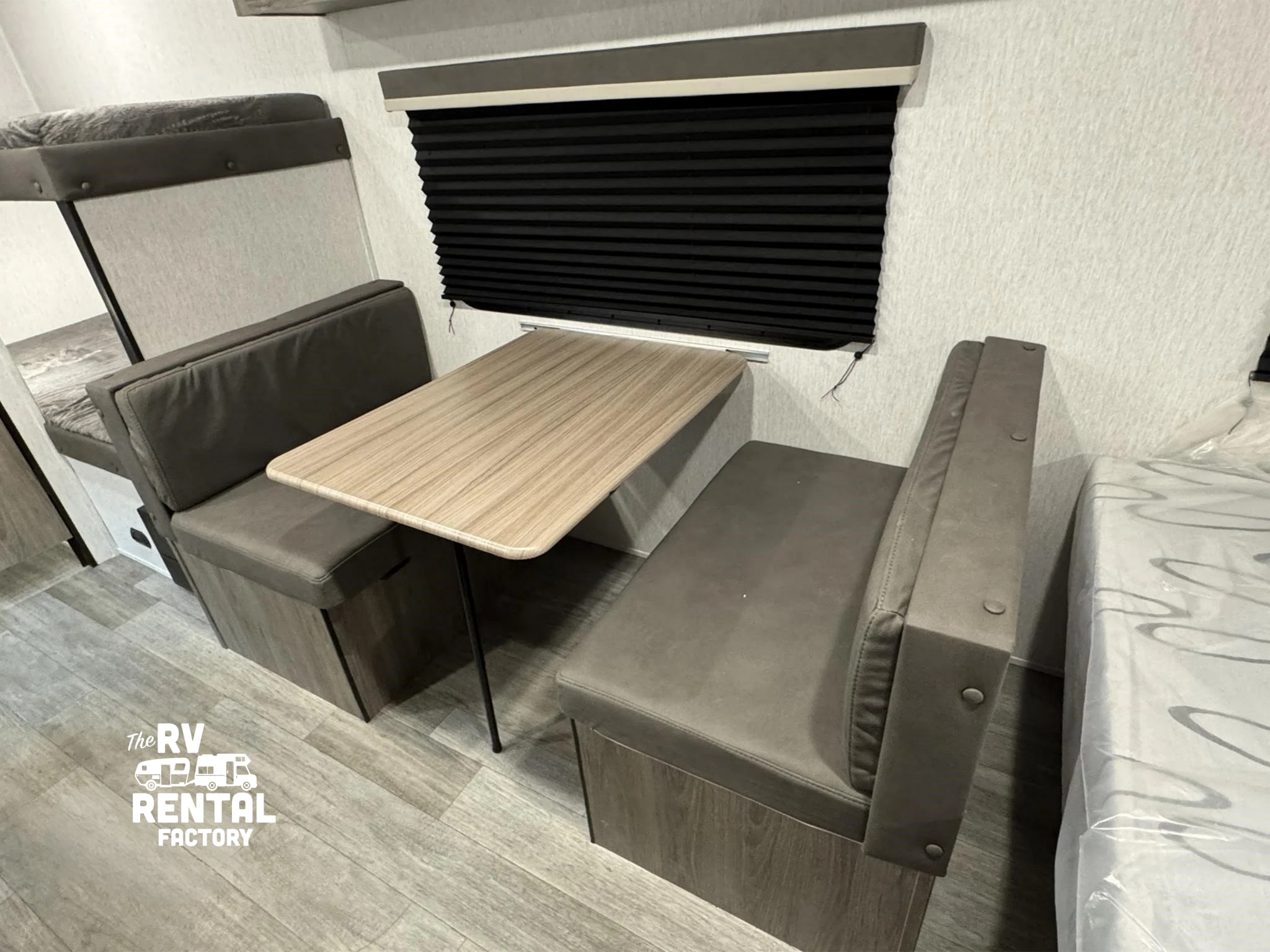 This RV rental offers a cozy dinette, bunk beds, and durable wood-look flooring, ideal for family travel and comfort.. Sunset Park RV Sun Lite LTD 2024