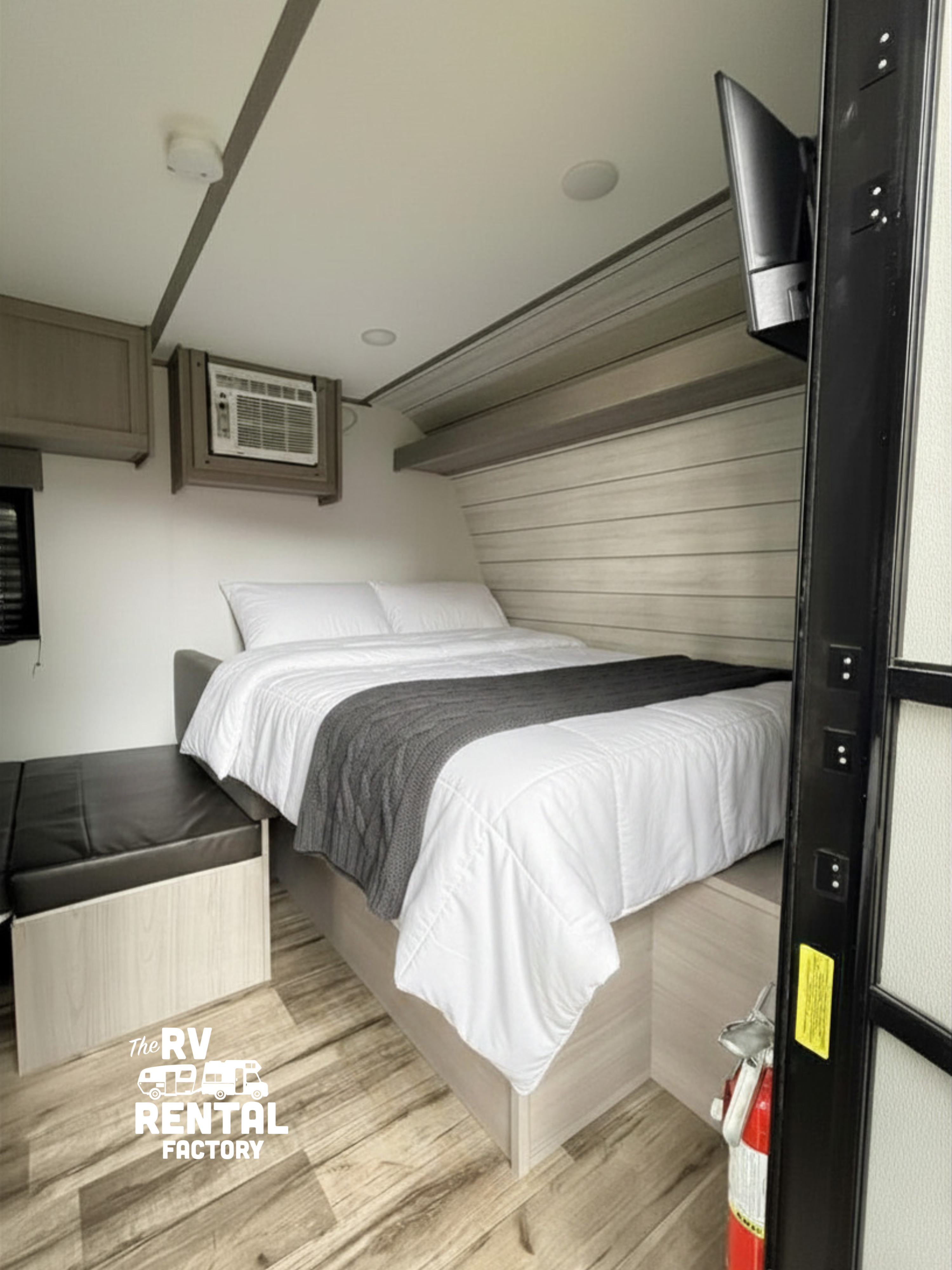 Cozy RV rental bedroom featuring a comfortable bed, AC unit, and TV, perfect for a relaxing road trip.. Dutchmen Coleman 2024