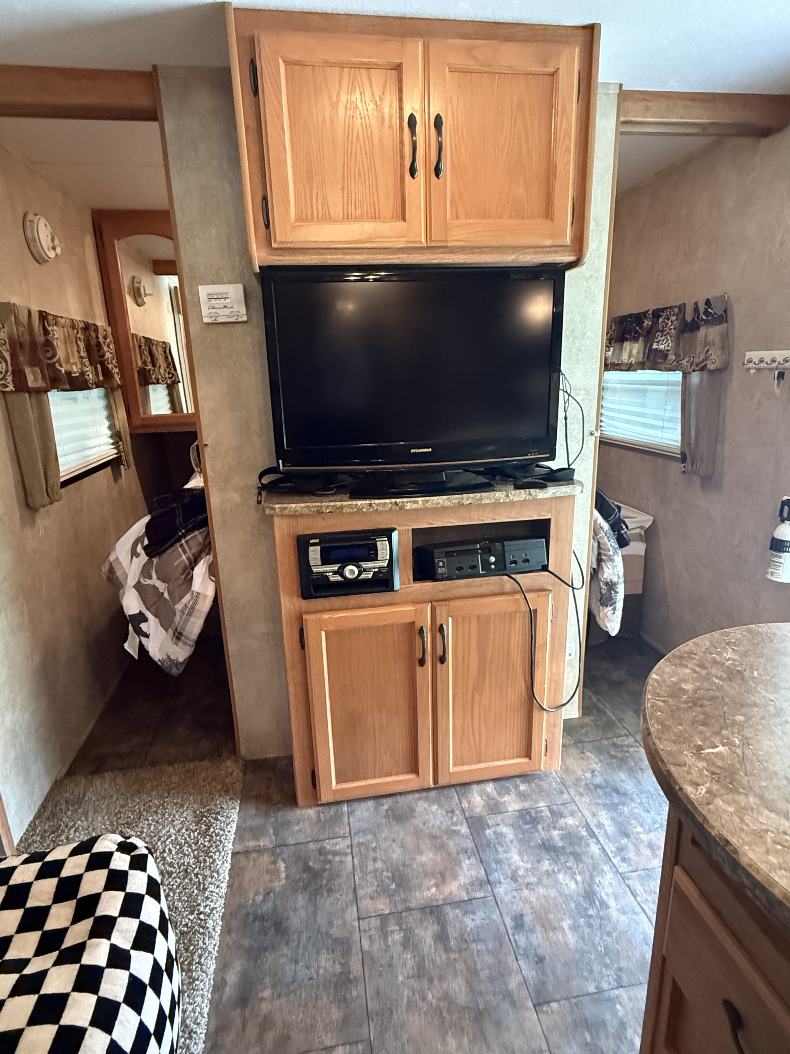 RV rental living space with TV entertainment center, wood cabinets, and access to a sleeping area for comfort.. Keystone RV Sprinter Select 2011