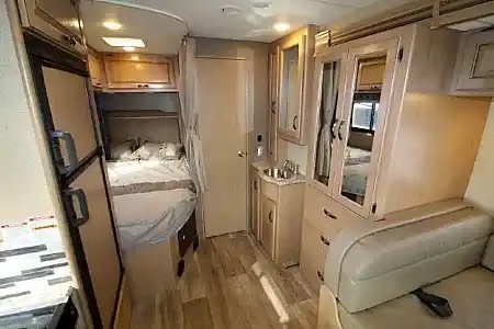 Spacious and functional RV rental interior featuring a cozy bedroom, compact kitchen/bath, and comfortable seating area.. Thor 4 winds 2018
