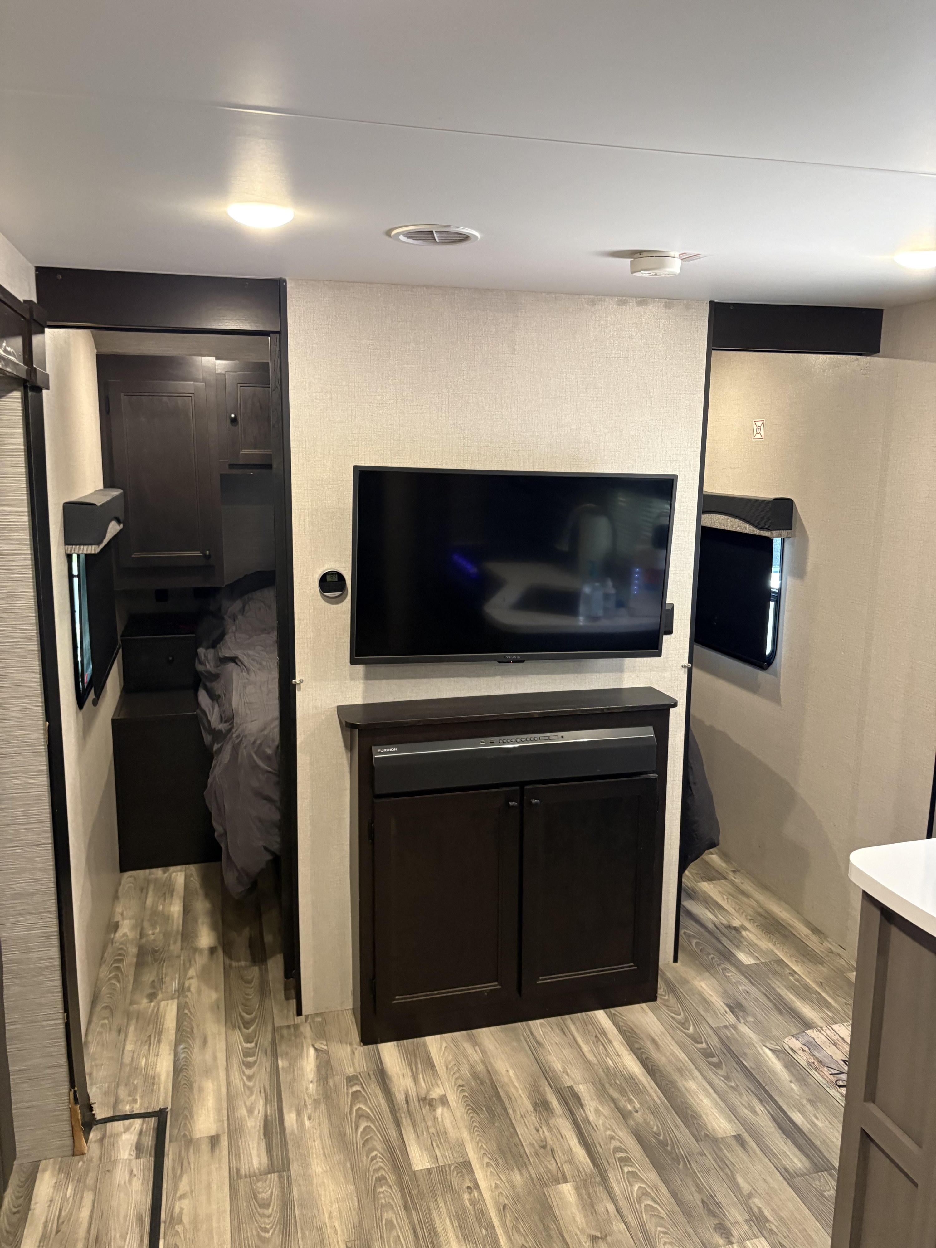 RV rental interior: Modern design with a TV, soundbar, and two bedroom entries, on wood-look flooring.. Starcraft Super Lite 2022