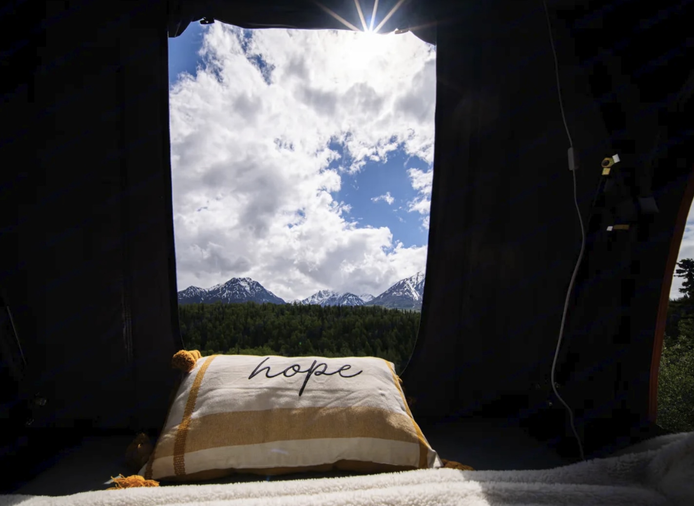 Relaxing inside an RV rental with a mountain view, cloudy sky, and a "hope" pillow. Perfect nature escape!. Ford Explorer 2016