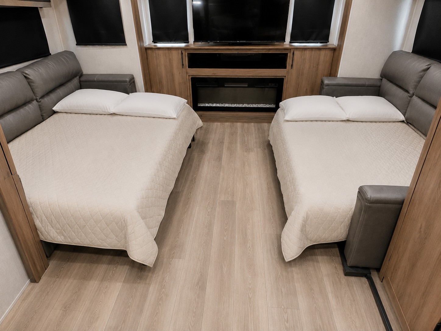 RV rental: Cozy interior with two beds, white pillows, quilted covers, wood flooring & a fireplace. Ideal for travel.. Grand Design Imagine 2024