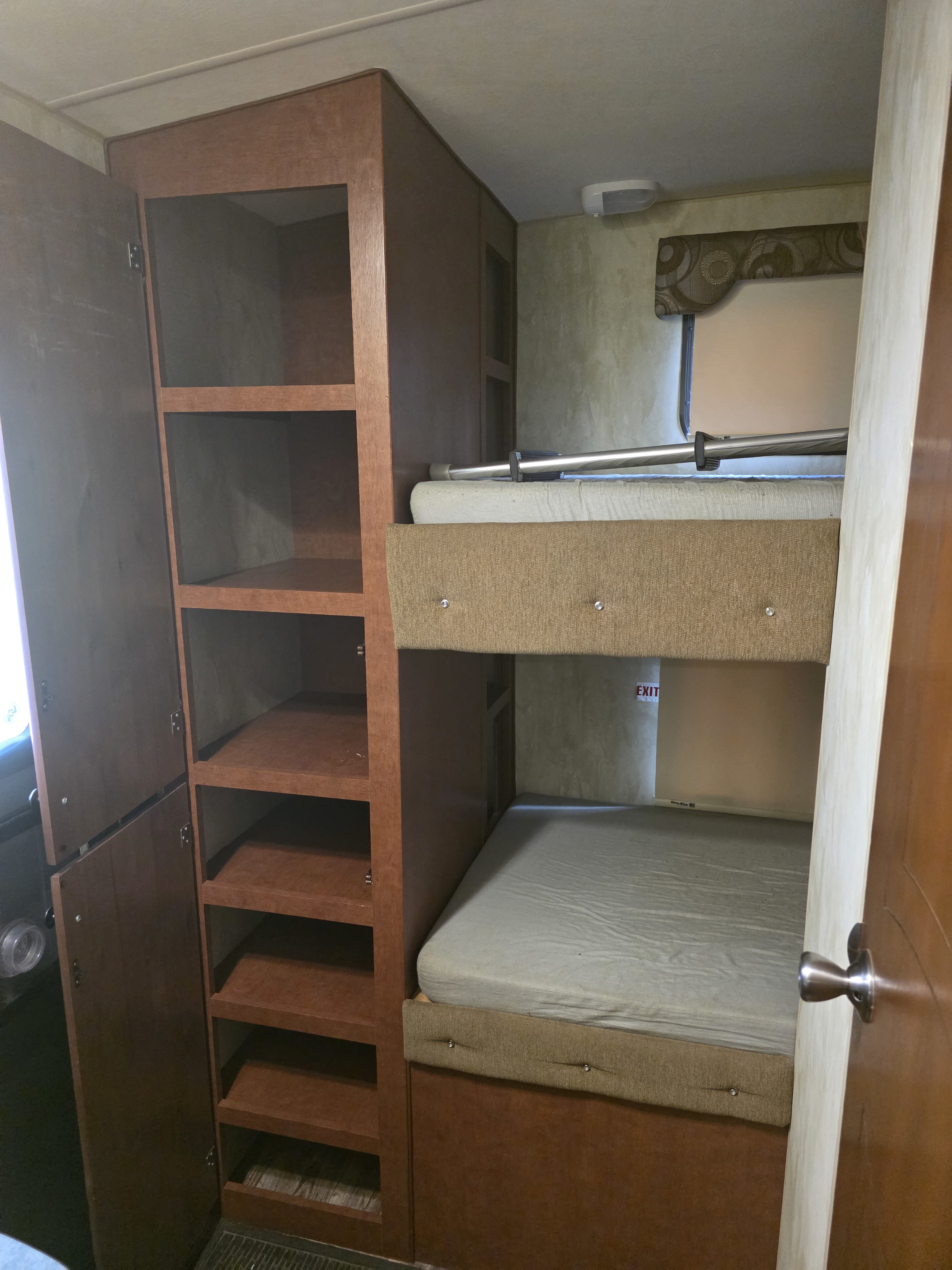 RV rental with comfy bunk beds and practical shelving. Ideal camper interior for family or group travel, maximizing space and storage.. Nash Nash Trailer 2019
