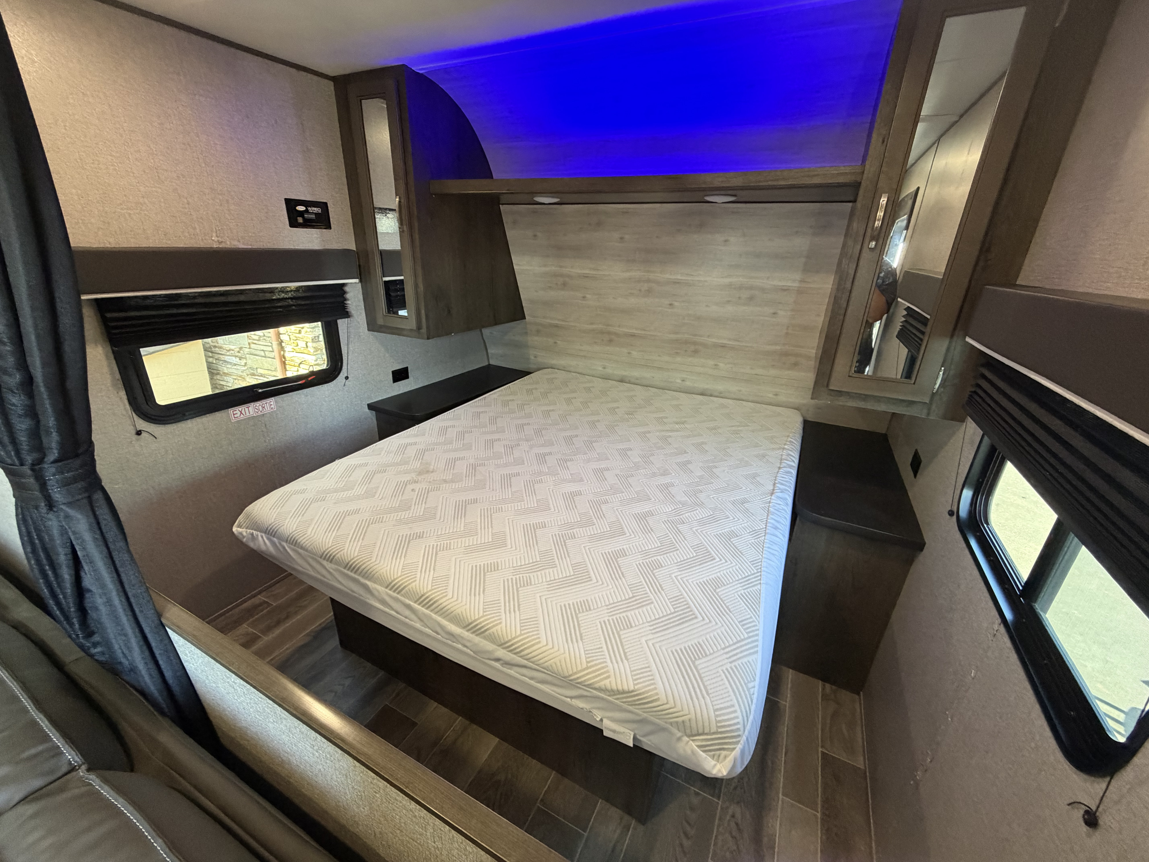 Modern RV rental bedroom featuring a comfortable bed, mirrored wardrobes, and soothing blue accent lighting for your next adventure.. Jayco Jay Flight SLX 2021