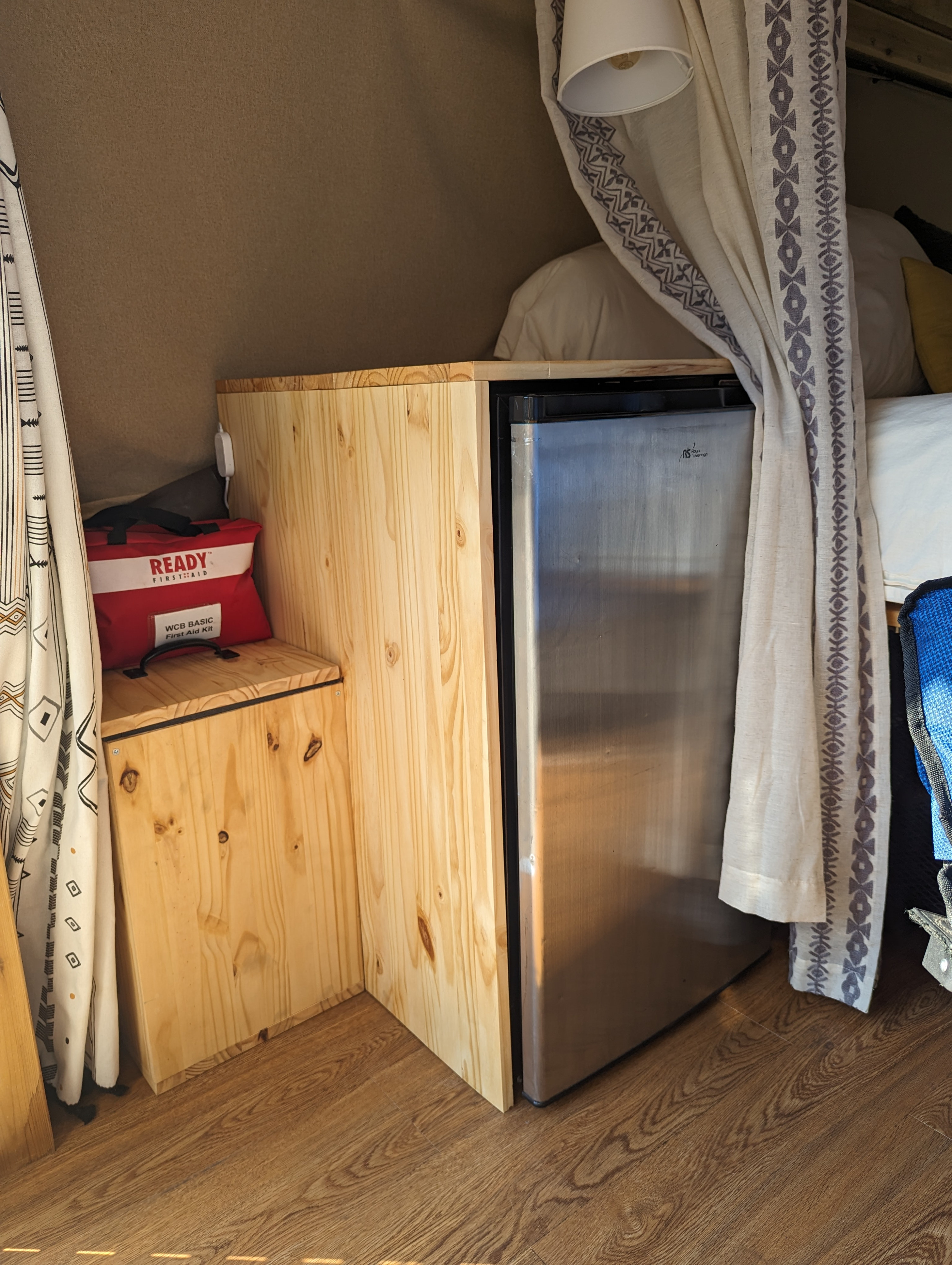 Compact RV rental interior with mini-fridge, custom storage, and first aid kit for comfortable travels.. Chevrolet Express 2011