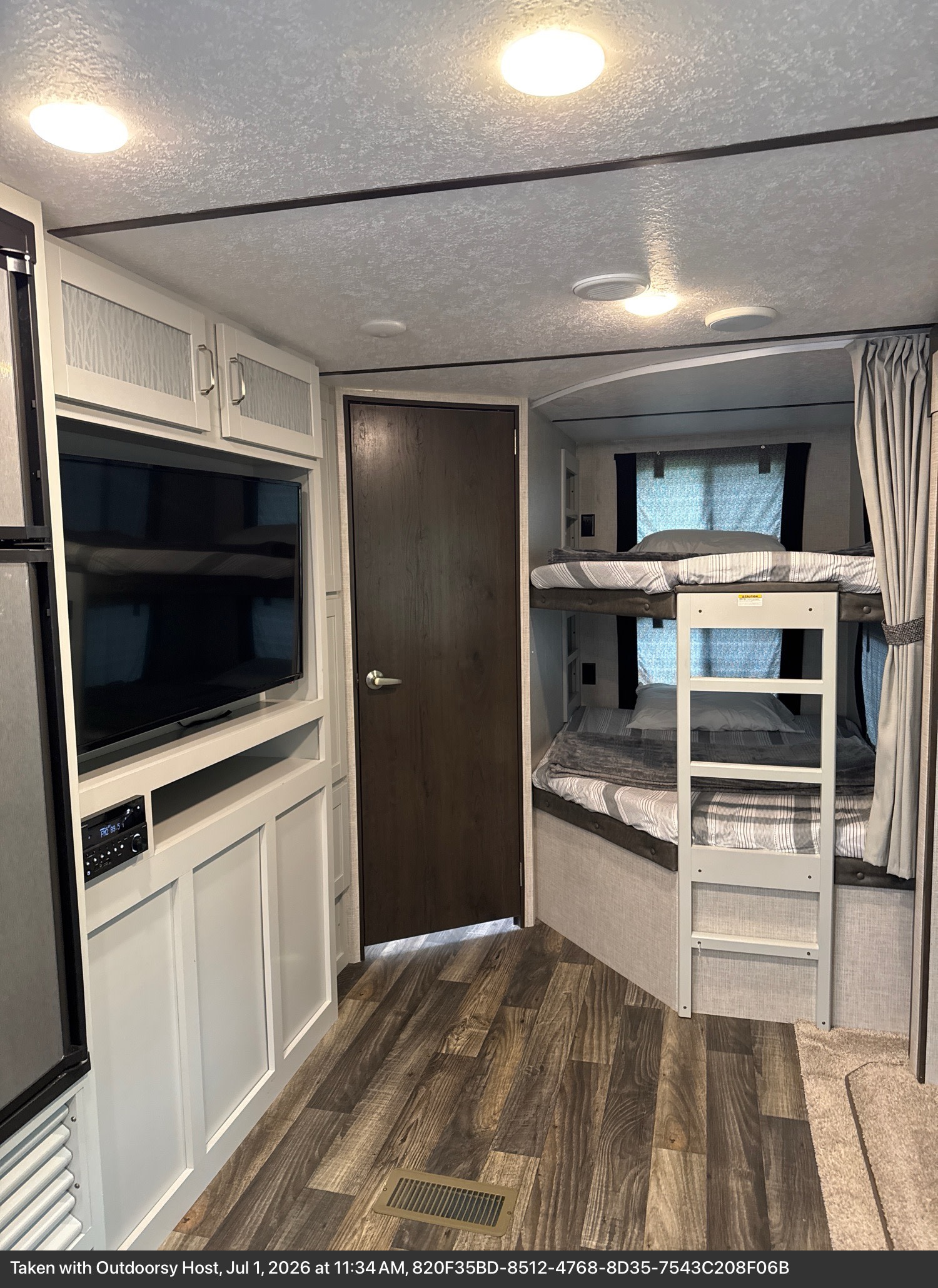 RV rental interior featuring comfortable bunk beds, a TV entertainment center, and stylish cabinets.. Keystone RV Bullet Ultra Lite 2020