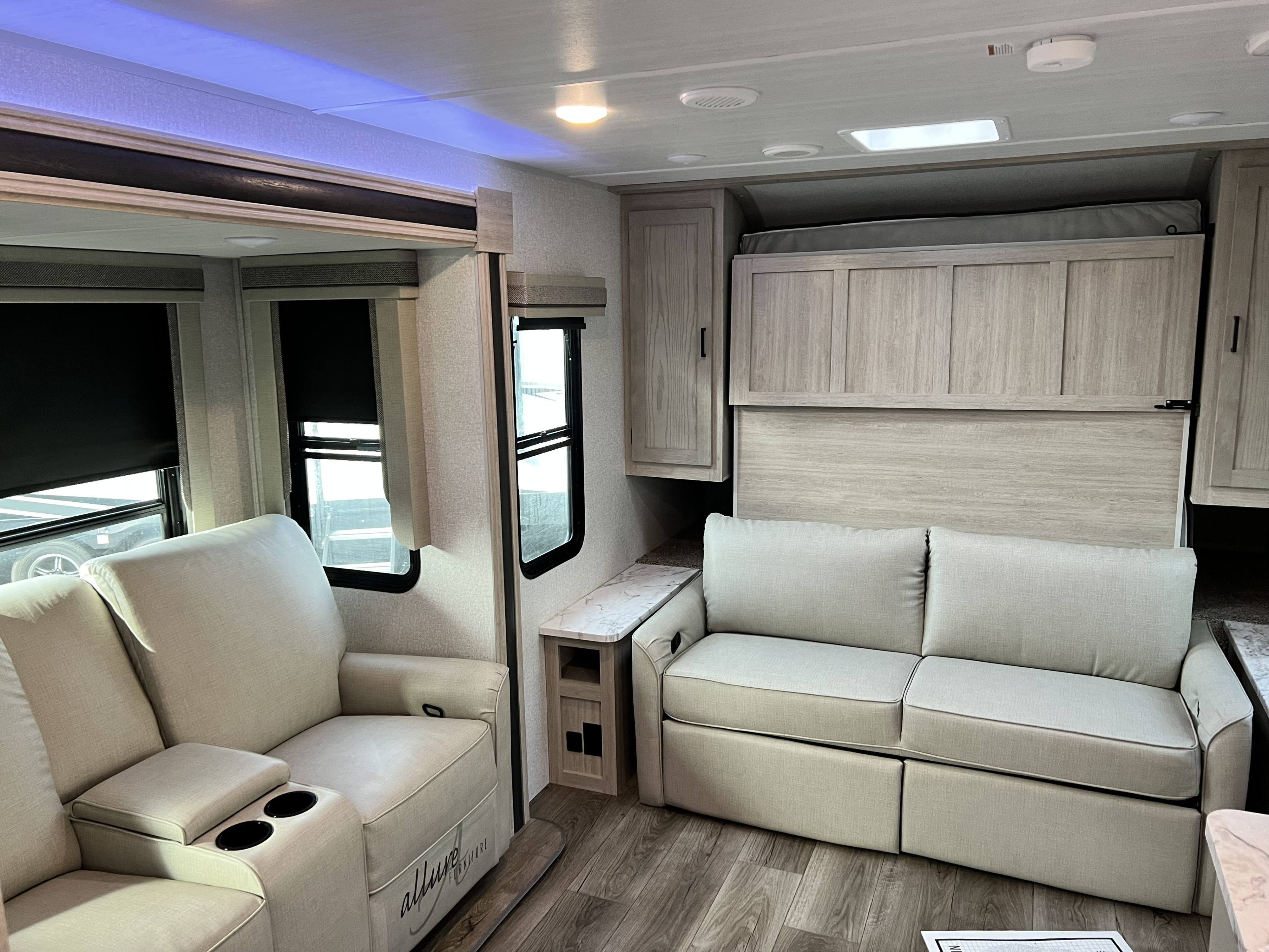 This spacious RV rental features a cozy recliner, sofa, and a cleverly folded Murphy bed for extra room.. East to West Alta 2022