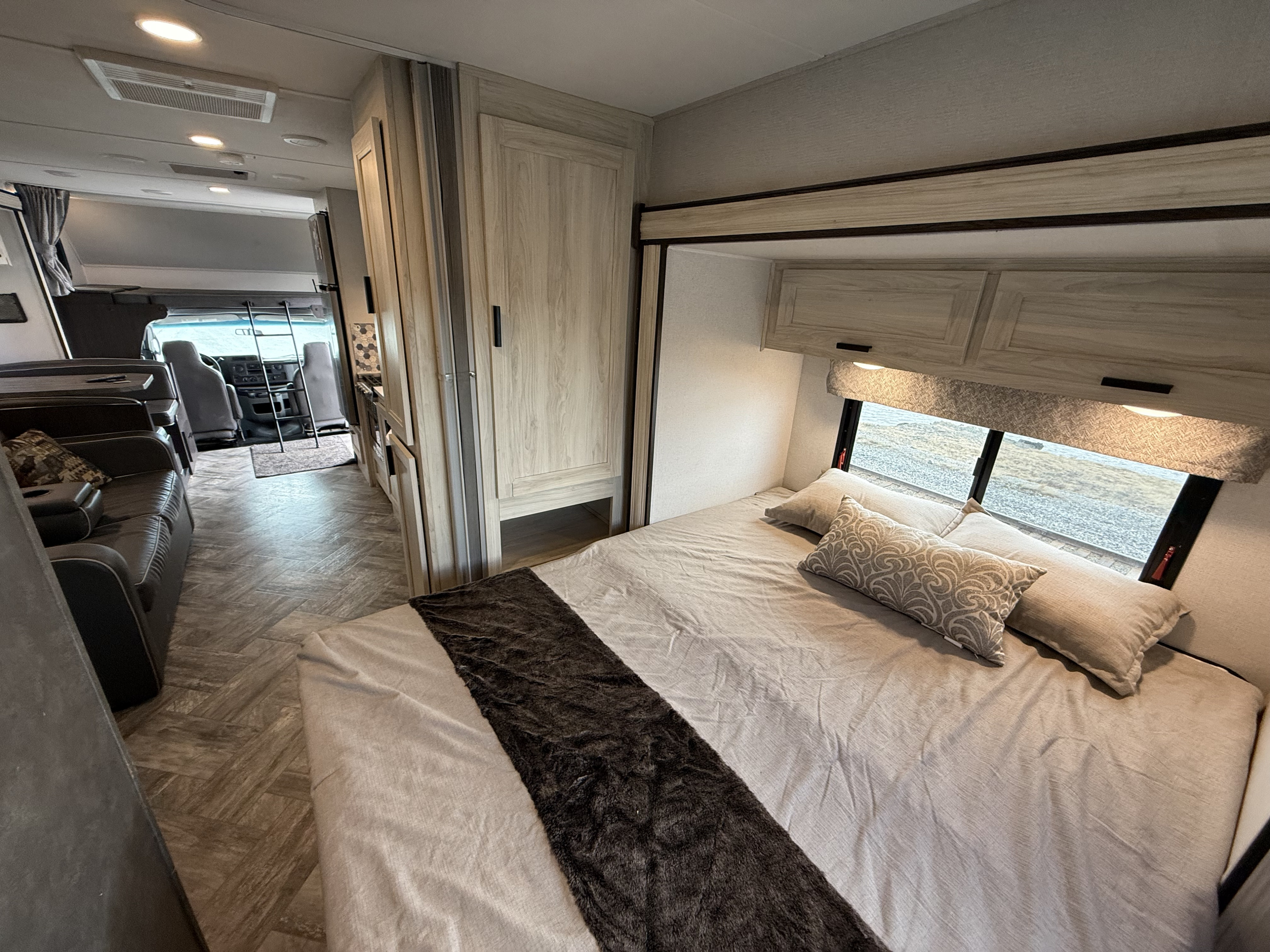 Modern RV rental interior featuring a comfortable bedroom, lounge area, and driver's cab view, ready for your next adventure.. Forest River Forester 2551 DSLE 2022