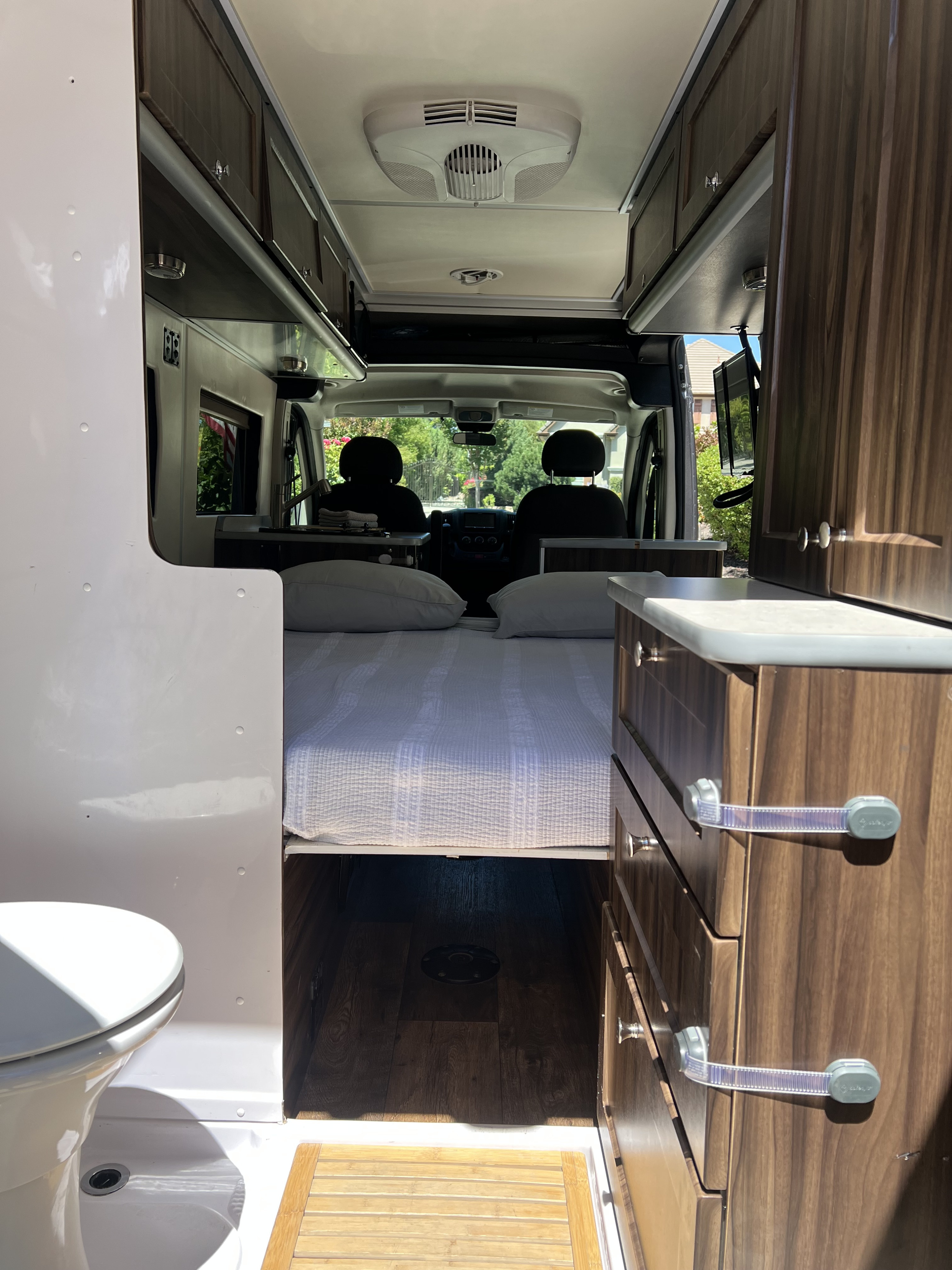 Inside an RV rental: a comfy bed, functional kitchen, bathroom, and overhead storage. Ideal for your mobile adventures!. Hymer Carado Banff 2017