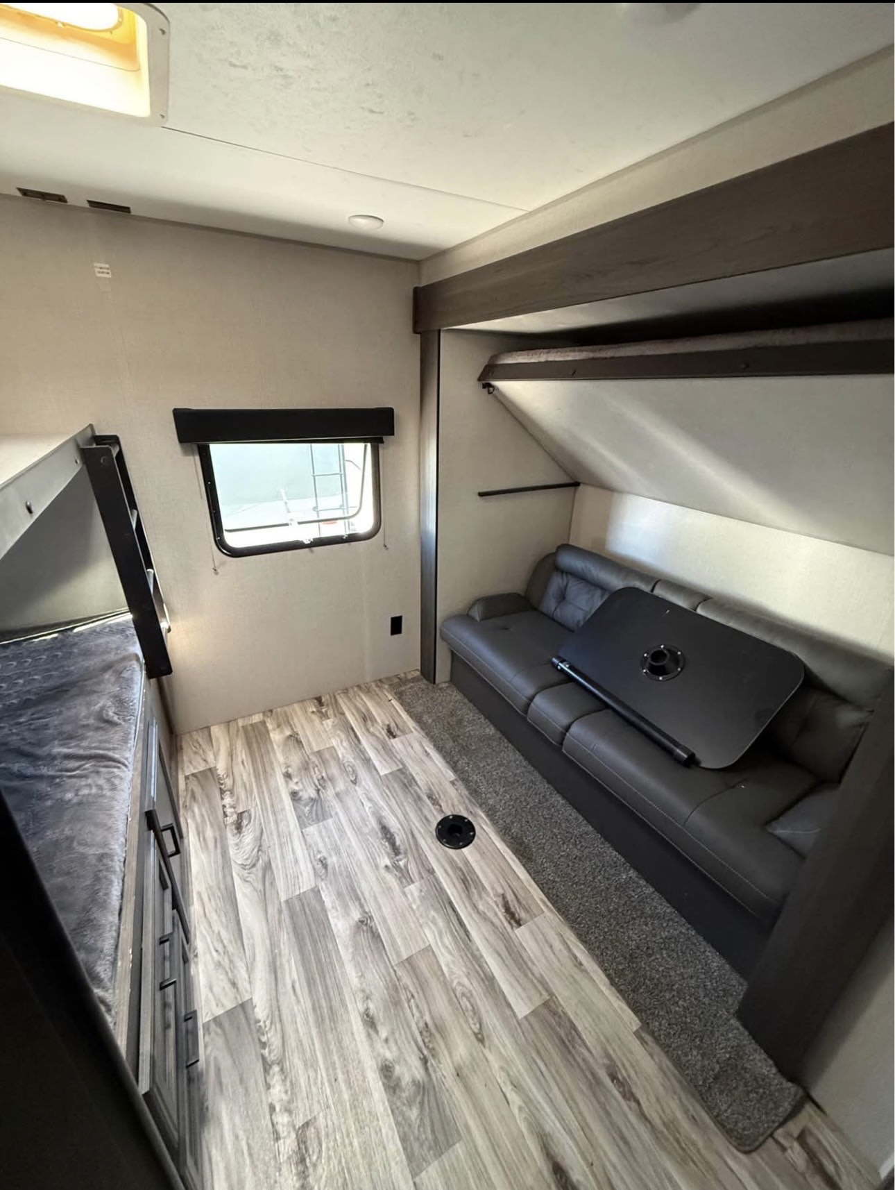 RV rental interior: Features bunk beds, a sofa with a table, window, and wood-look flooring. Ideal compact living space.. Sport Trek Sport Trek Trailer 2021