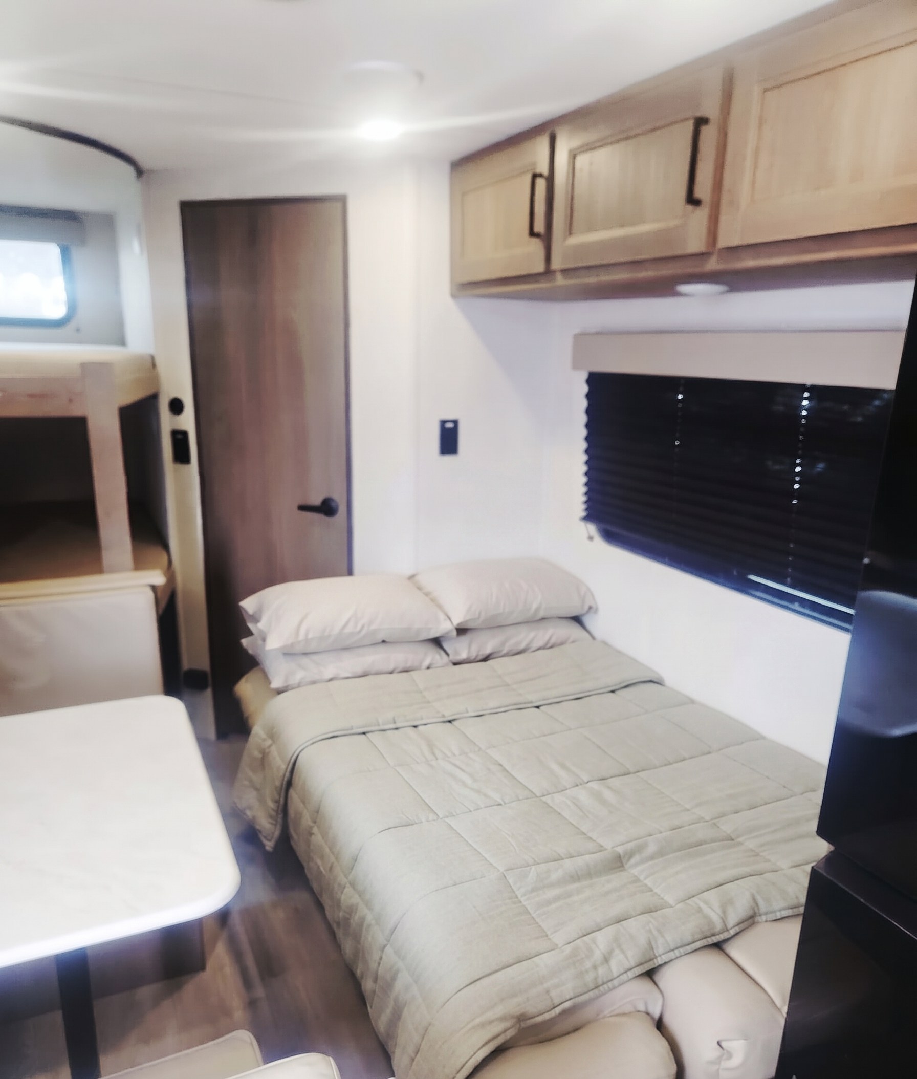 Cozy RV rental interior with bunk beds, a comfy bed, dining area, and cabinets. Perfect for your next adventure!. Grand Design Transcend Xplor 2025