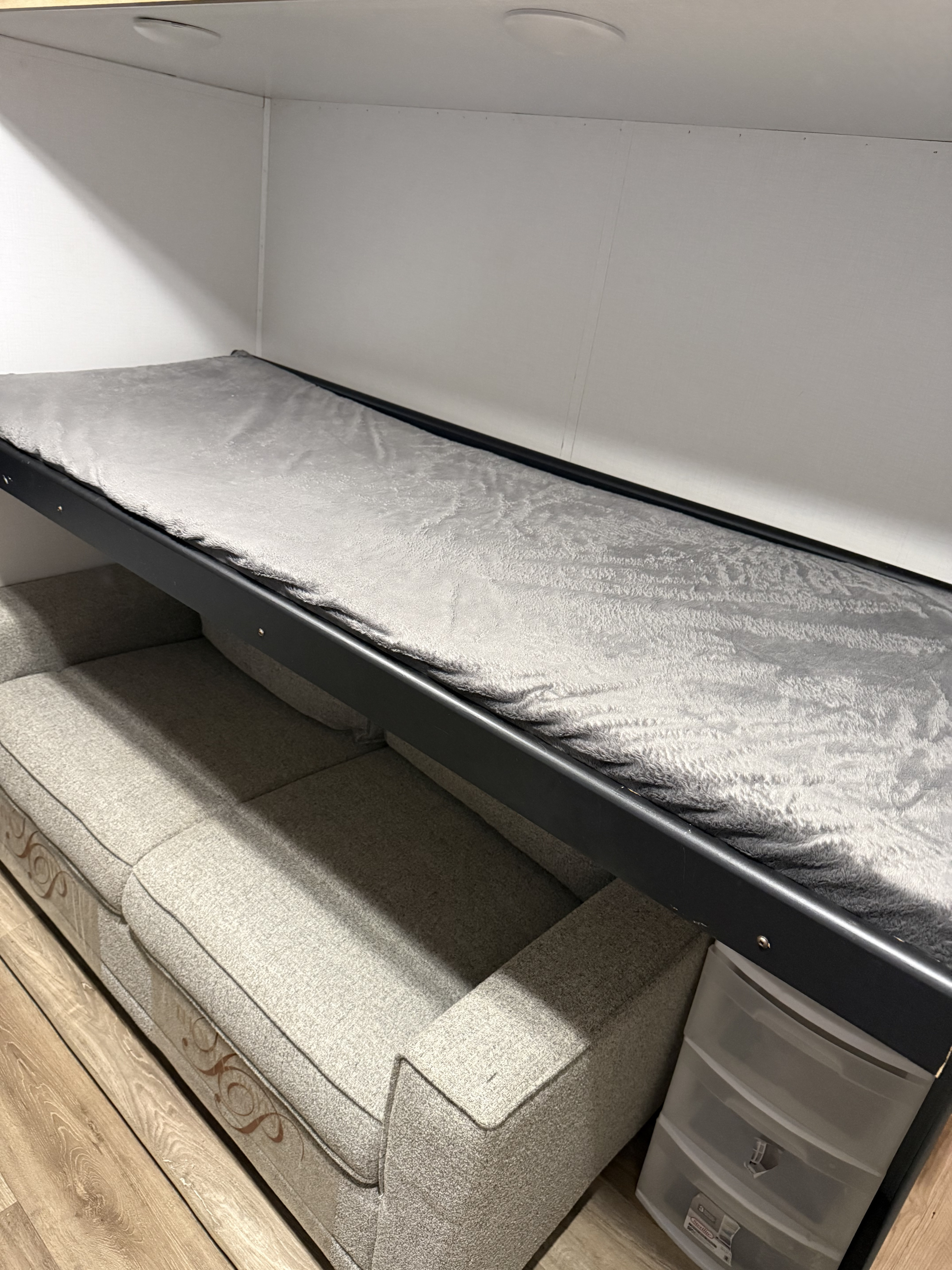 RV rental: Compact space with a grey bunk bed over a light grey sofa, including handy clear storage drawers.. Keystone RV Outback 2023