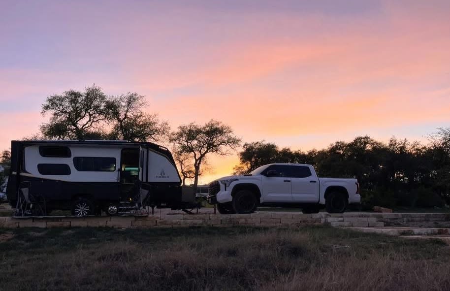 The Ember and tow vehicle silhouetted against a colorful sunset