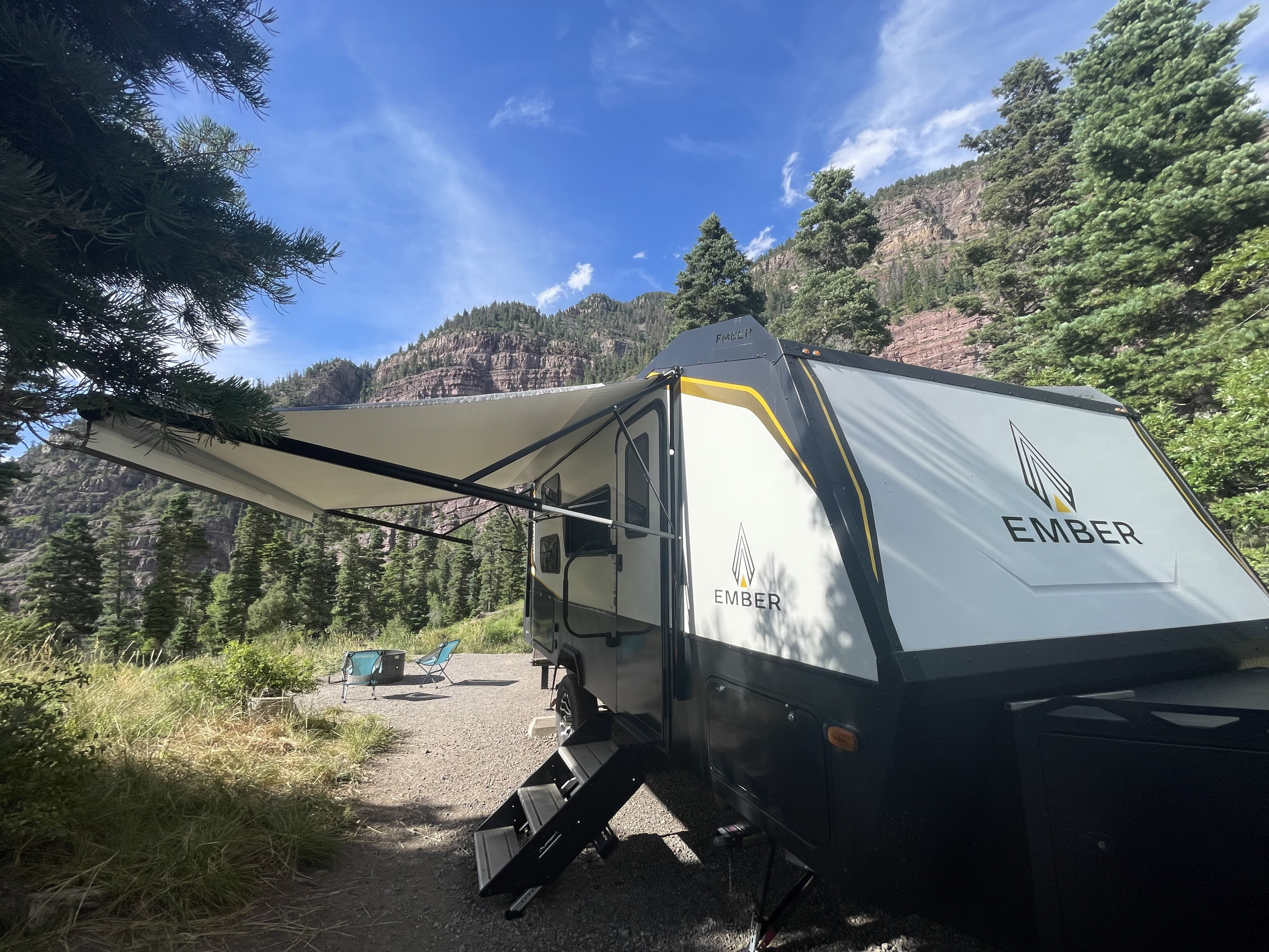 The Ember set up beneath its awning at a mountain campsite